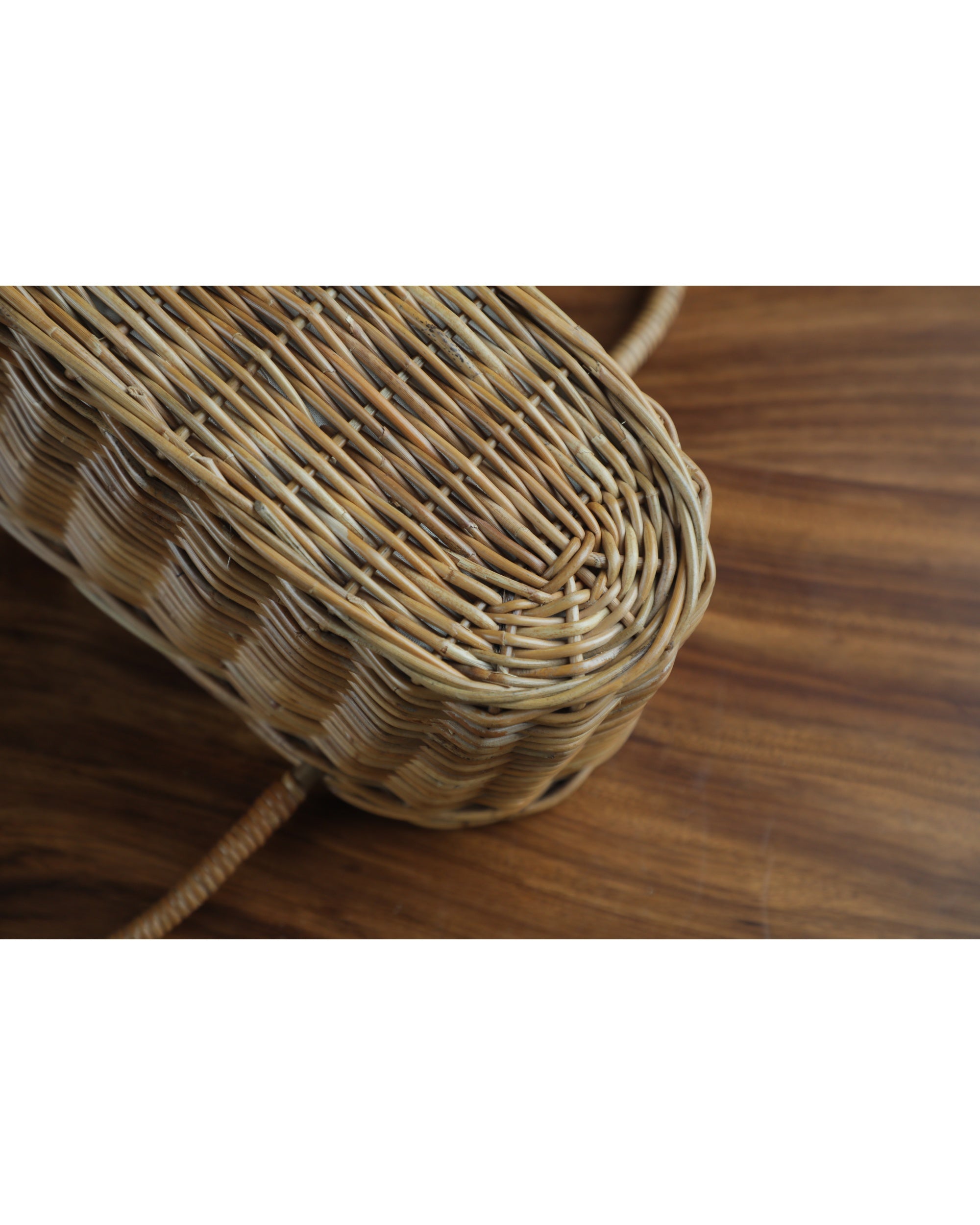 Handwoven natural rattan Ann handbag with woven texture and curved bottom