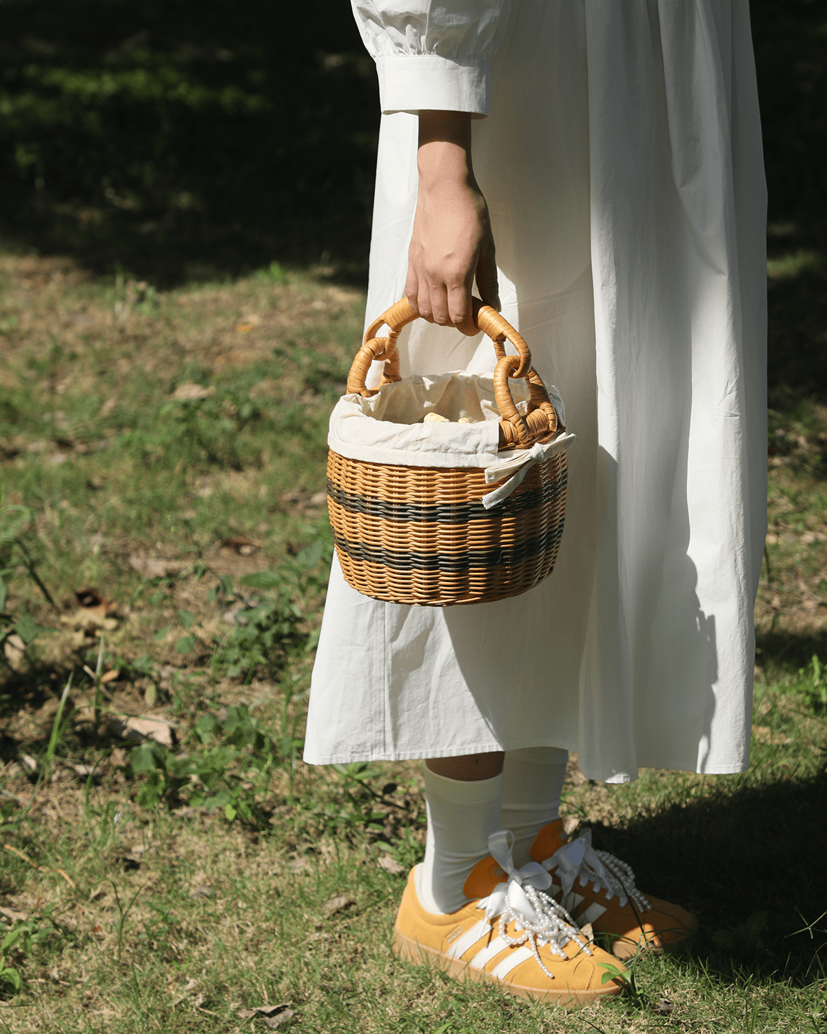 Small handwoven rattan picnic bucket with contrasting weave and white cotton lining.