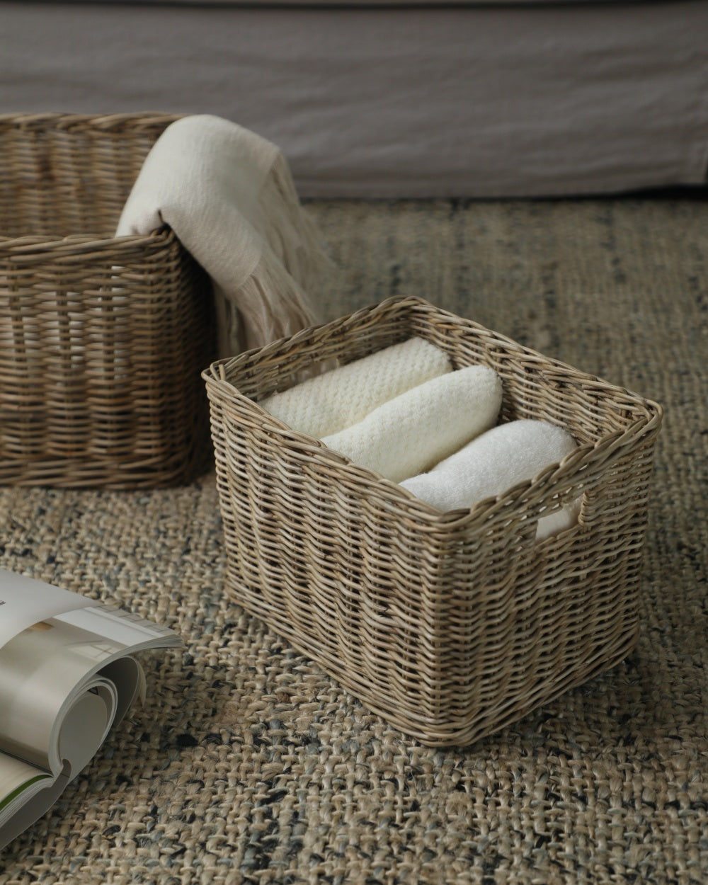 Loma Storage Basket: Rectangular, hand-woven natural fiber storage basket holding white towels.