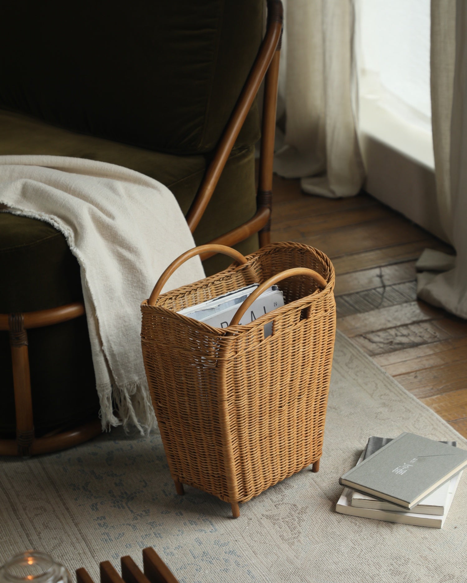 Woven rattan Luna storage basket, tapered design, holding books and magazines.