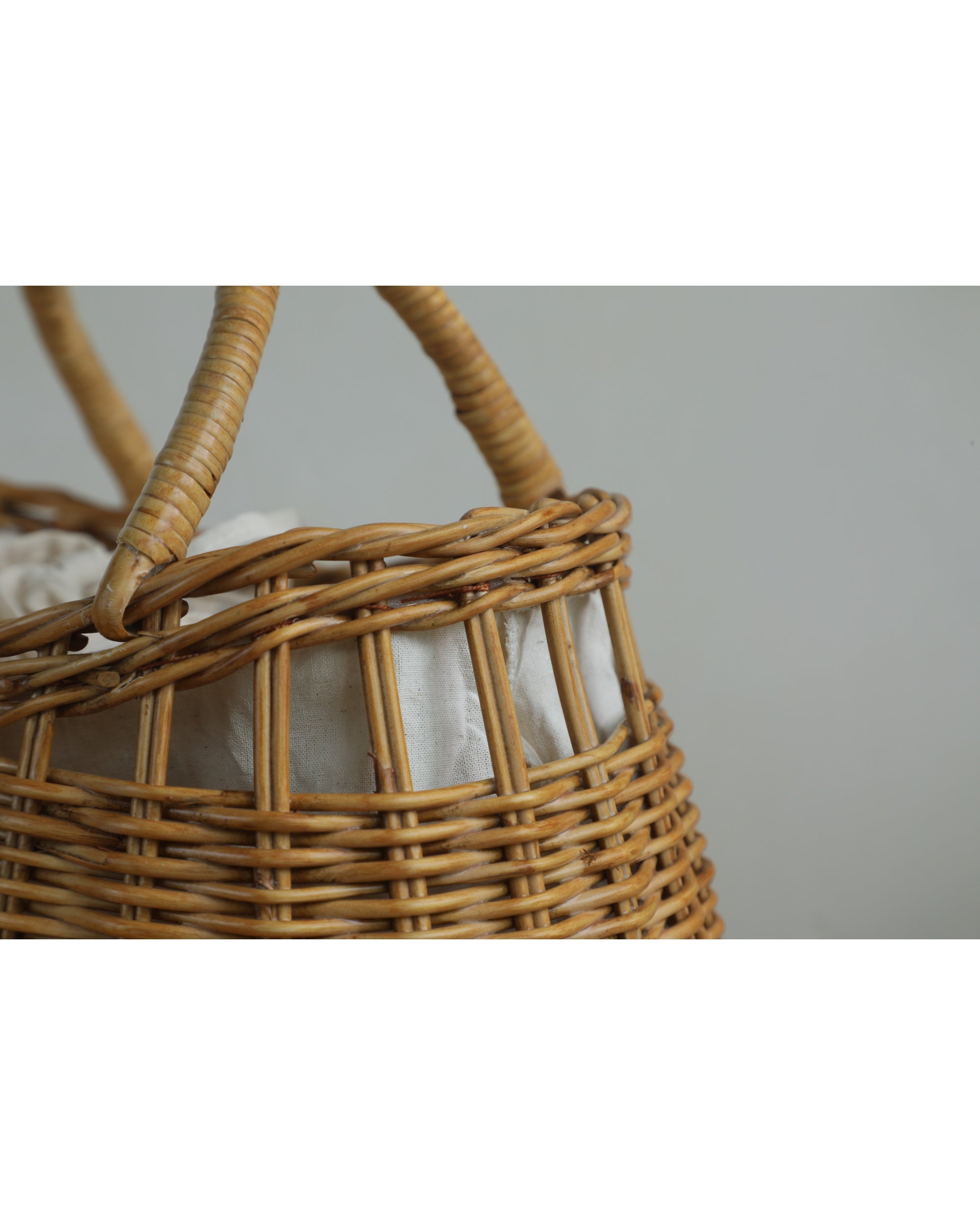 Ivy Hand Bag: Handcrafted woven natural rattan with curved handles and cream fabric lining.