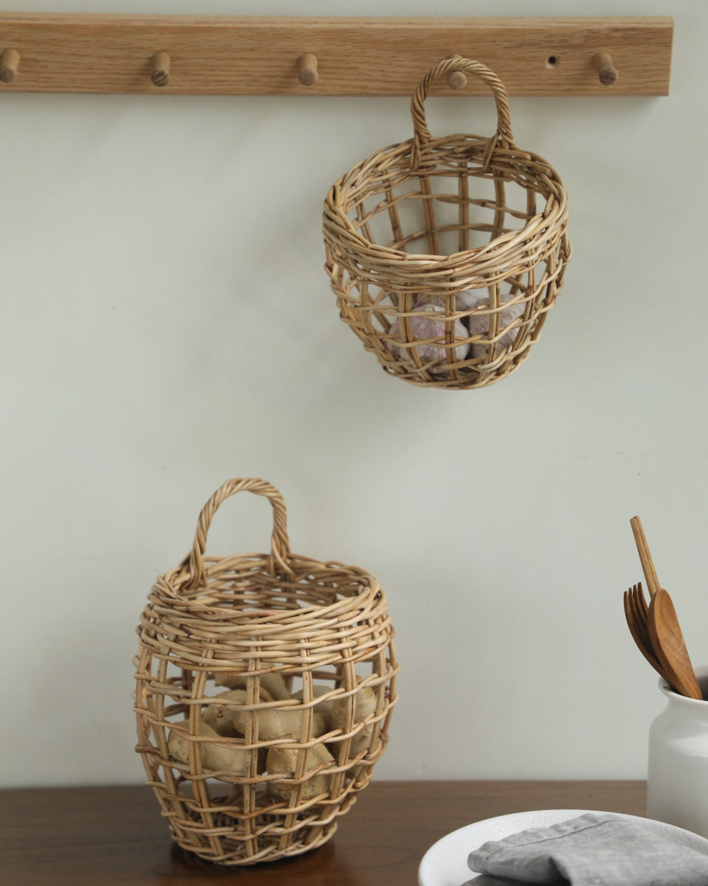 Cove hanging basket, hand-woven natural rattan with open-weave, holding garlic and ginger.
