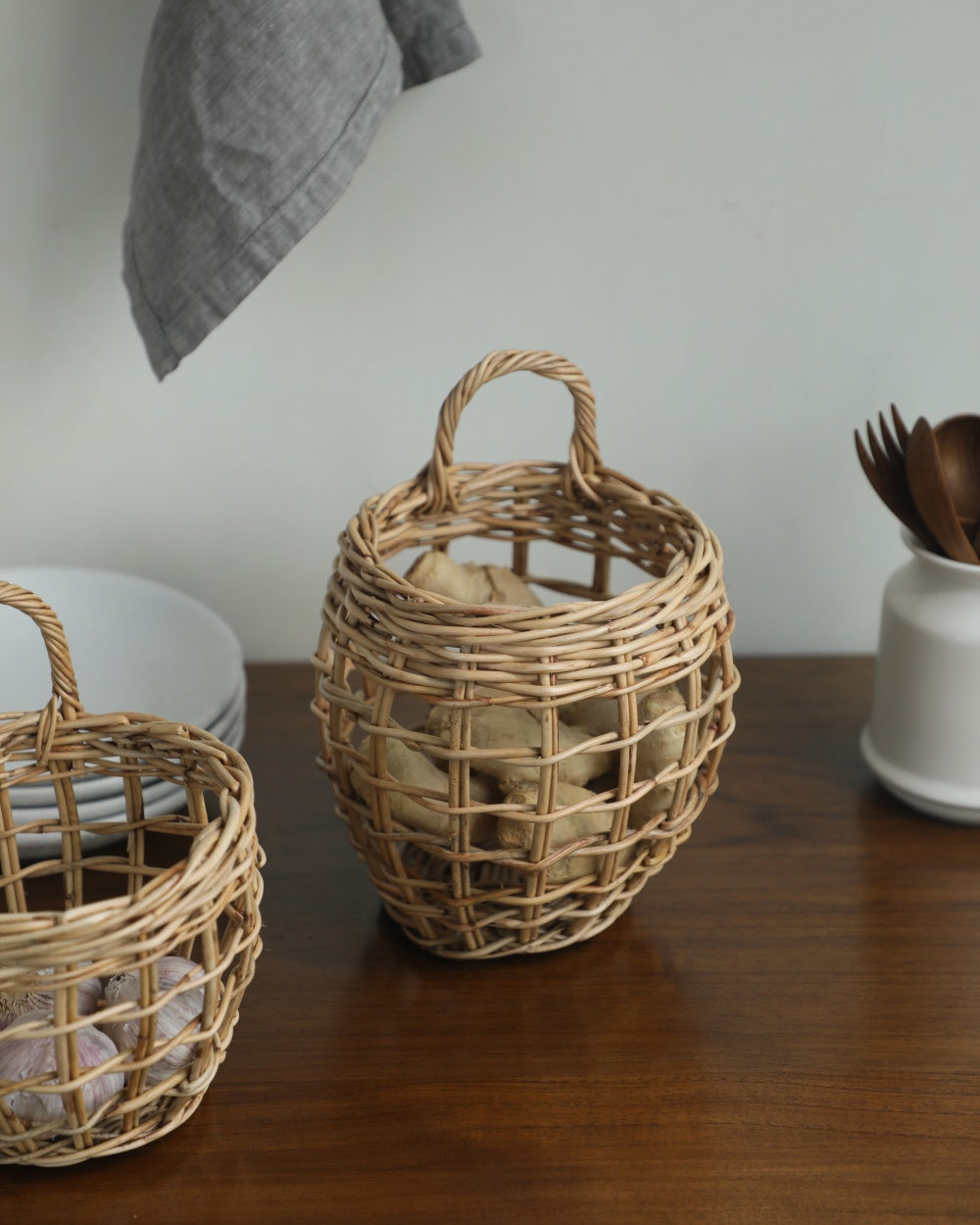 Natural rattan Cove Hanging Basket, hand-woven open weave, arched handle, holds ginger.