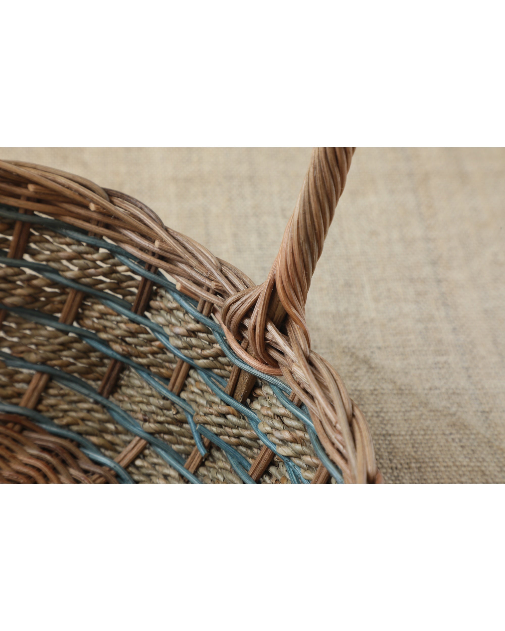 Woven Viney Tote Basket with natural rattan and green vine-like accents, featuring a twisted handle.
