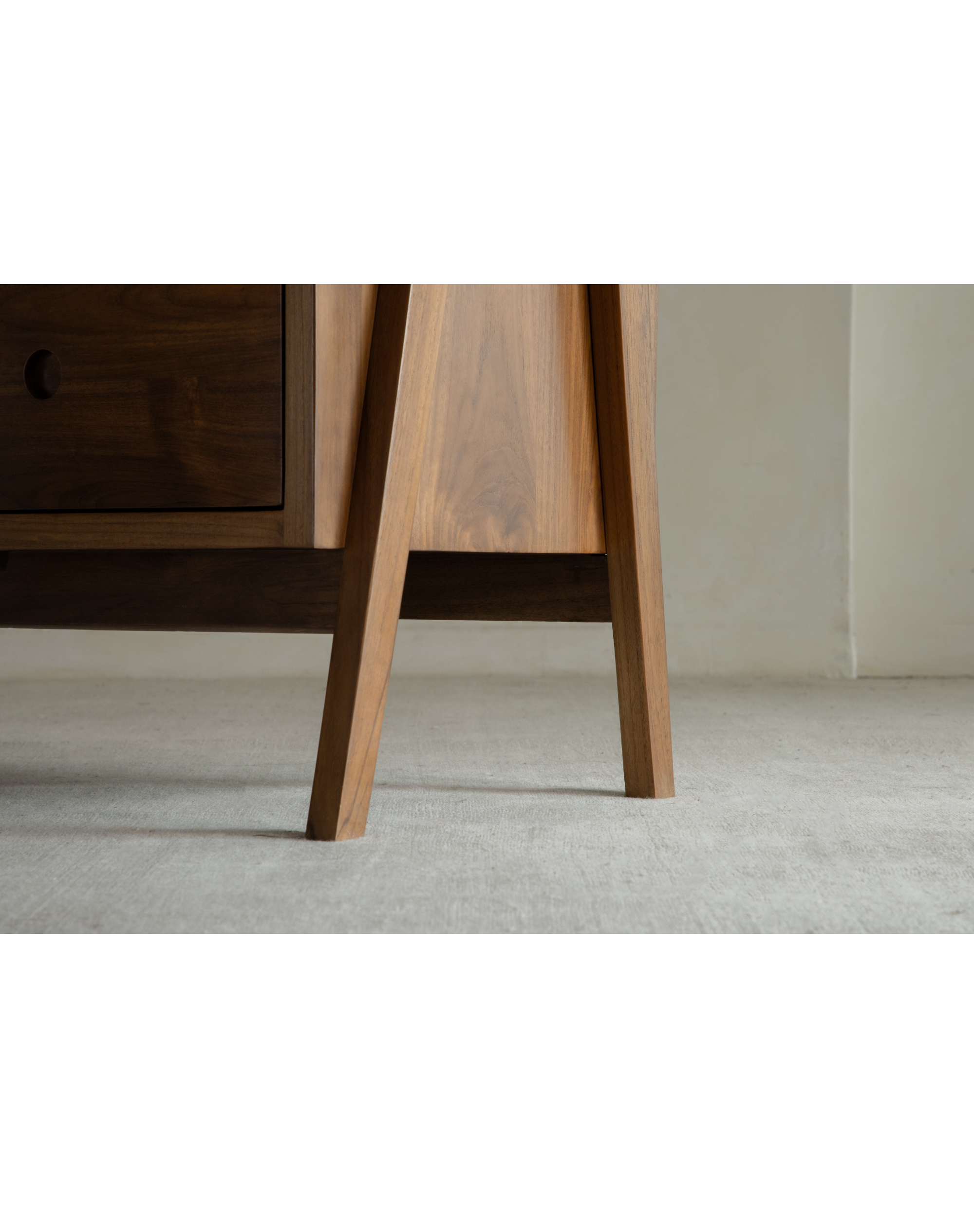 Close-up of teak No.23 sideboard base with characteristic angled triangular legs.