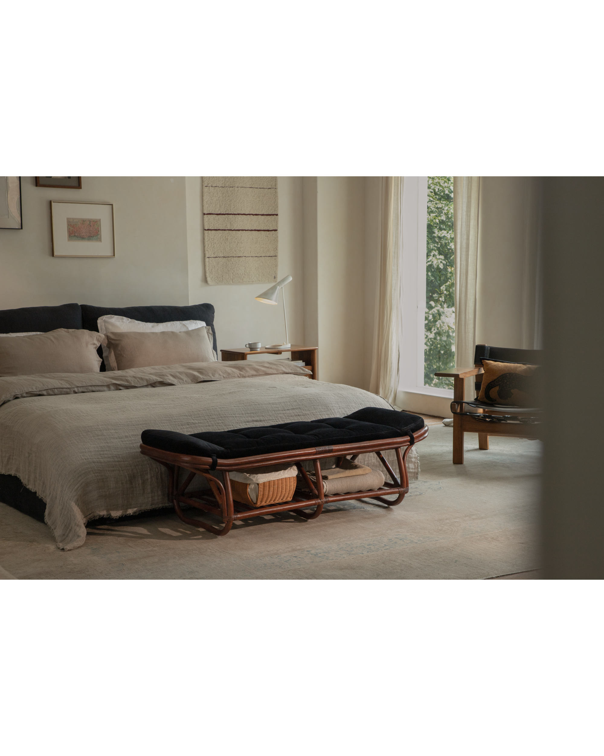 Twyla Storage Bench with rattan frame and black corduroy cushion in a bedroom.