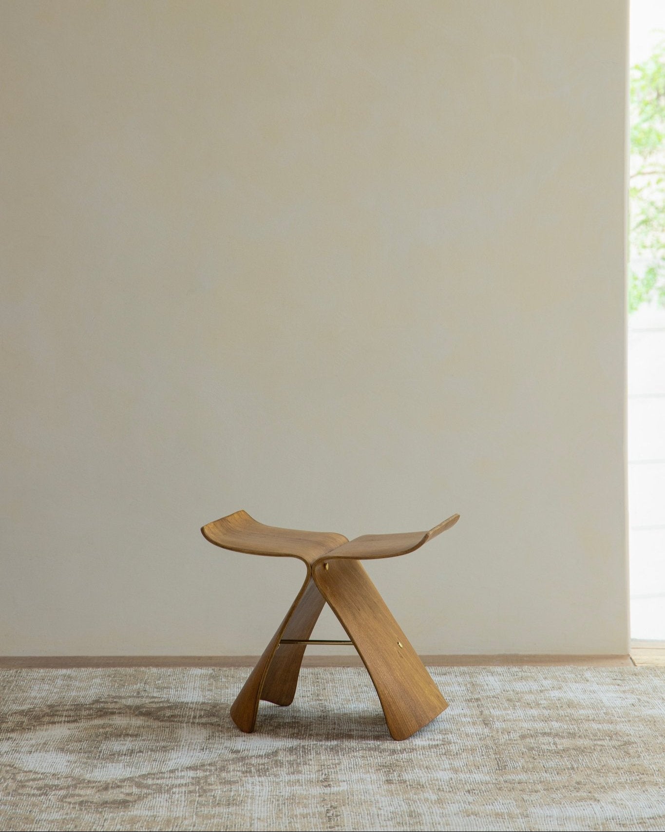 Butterfly Stool in natural wood finish, classic modern design, solid bent wood construction, elegant seating.
