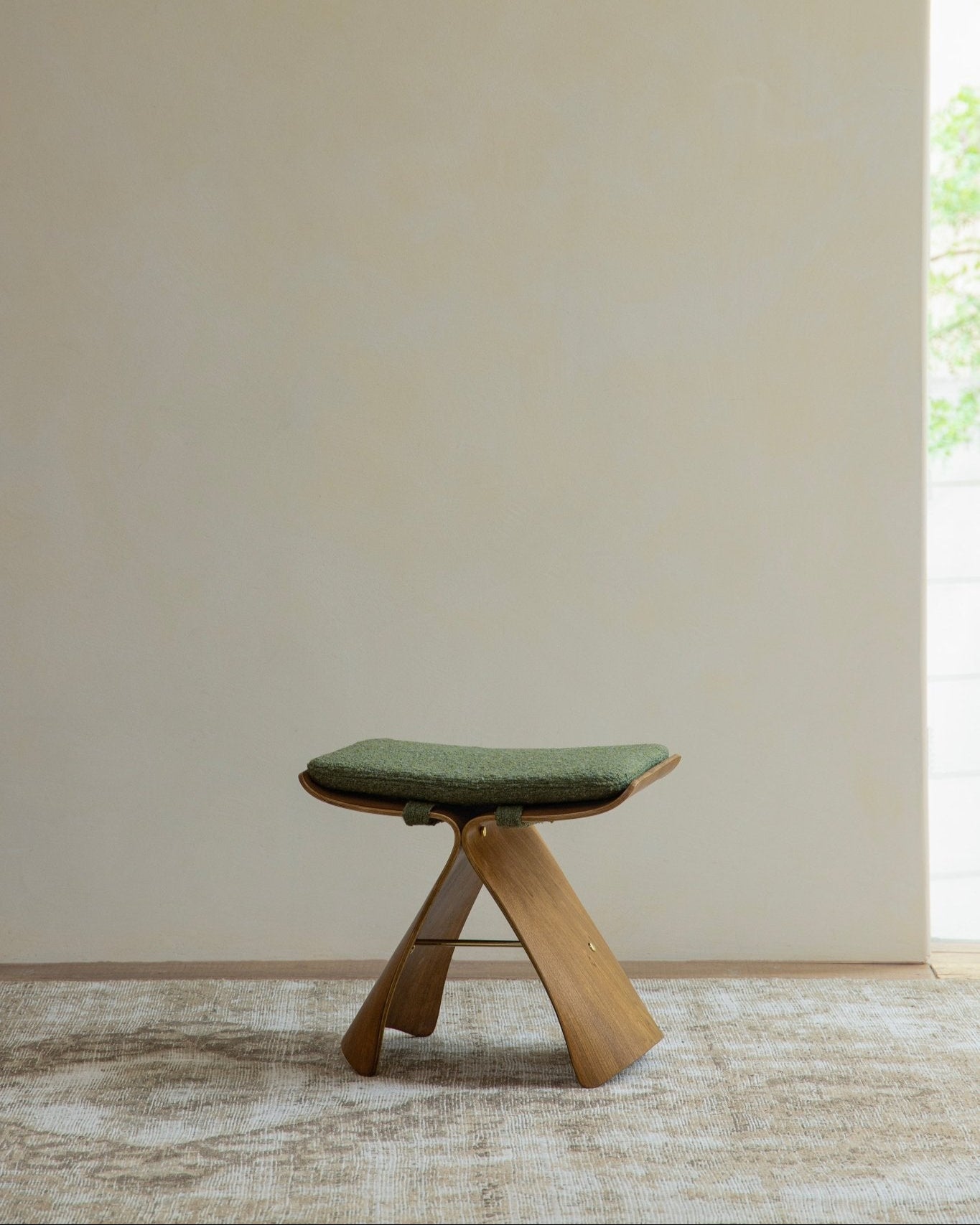 Butterfly Stool in dark wood with green cushion, classic modern design, elegant seating, solid wood bent construction