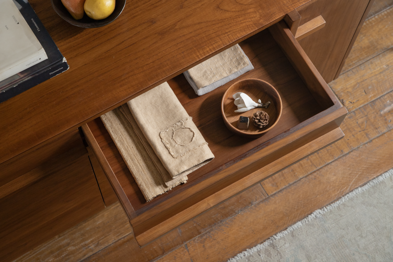 NO.42 Teak Sideboard drawer: linen napkins, decorative bowl with white flower, pine cone.
