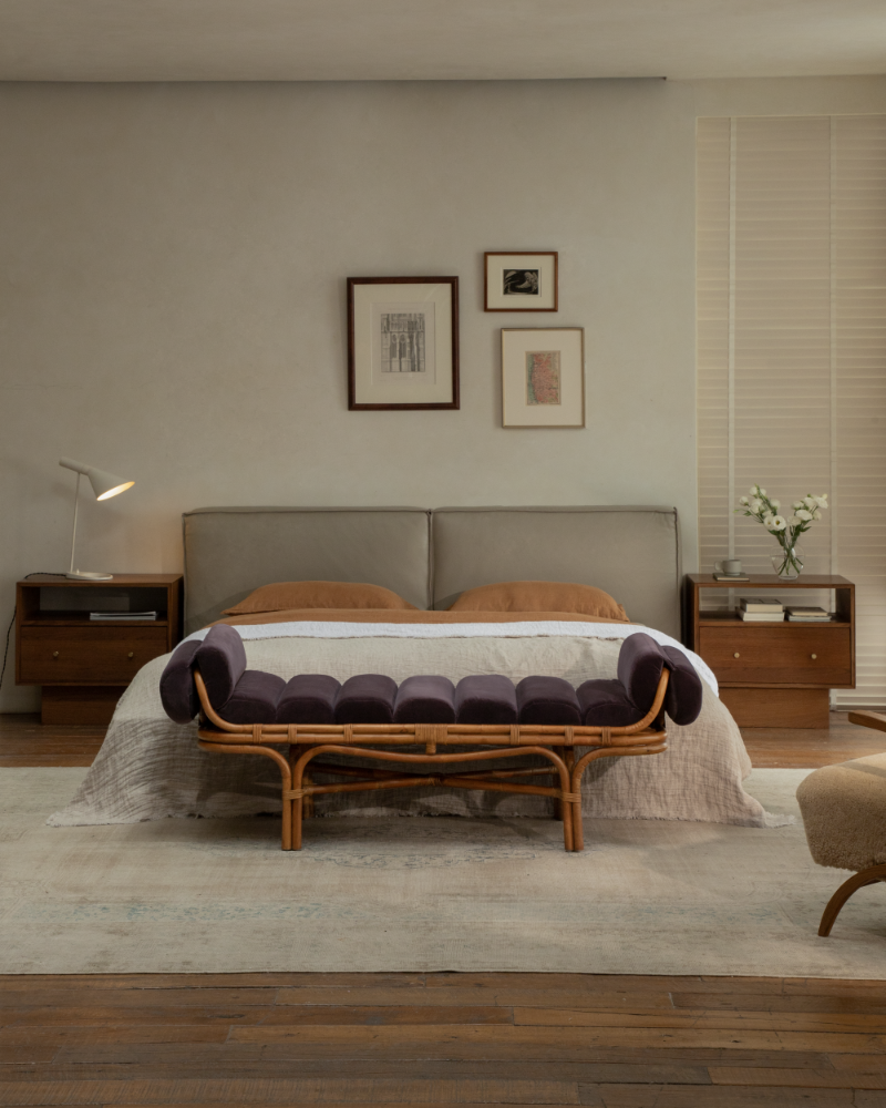 Bridget Bench featuring a natural rattan frame and deep velvet seat, styled in a bedroom.