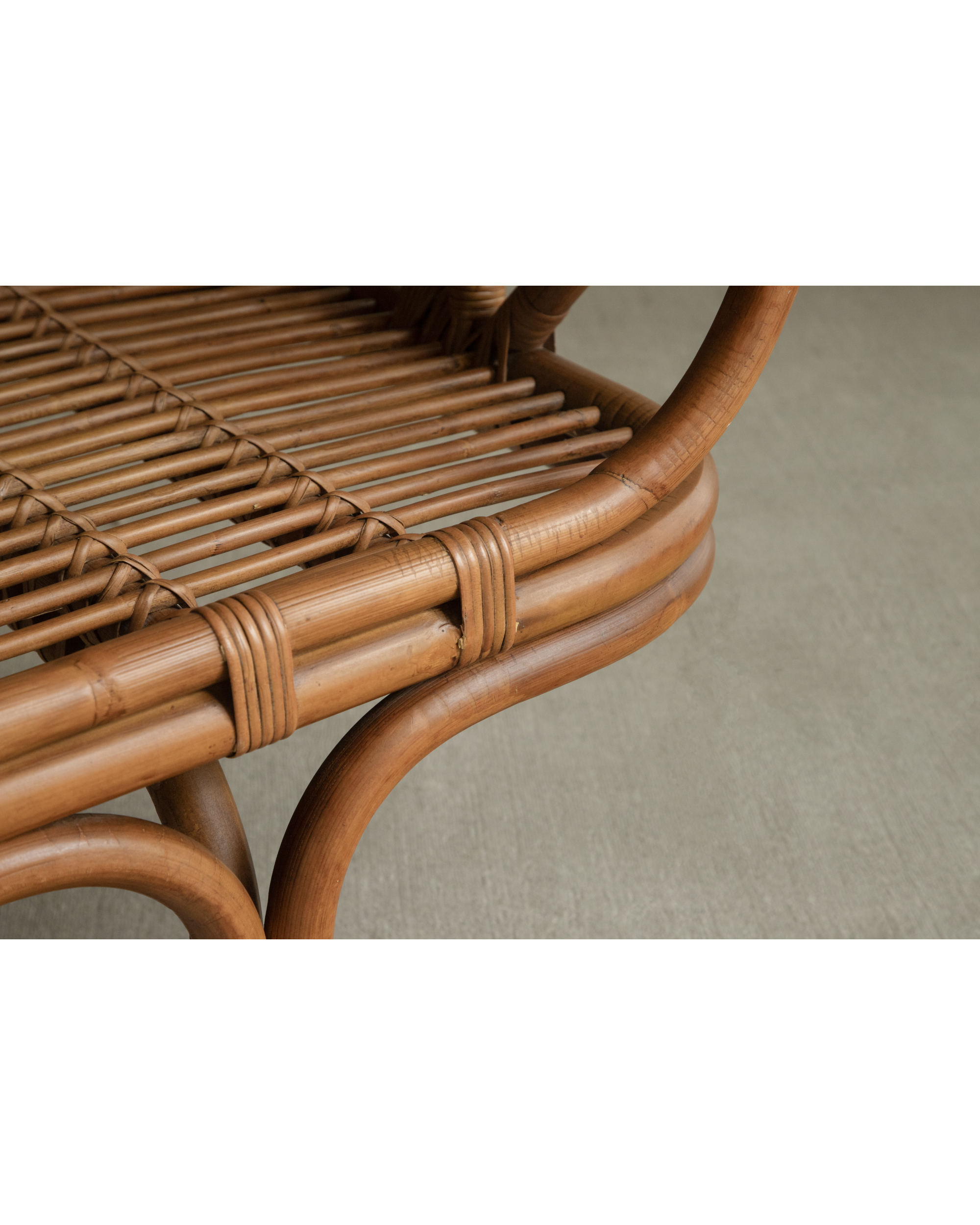 Bridget Bench detail: intricately woven rattan seat and smooth curved cane frame.