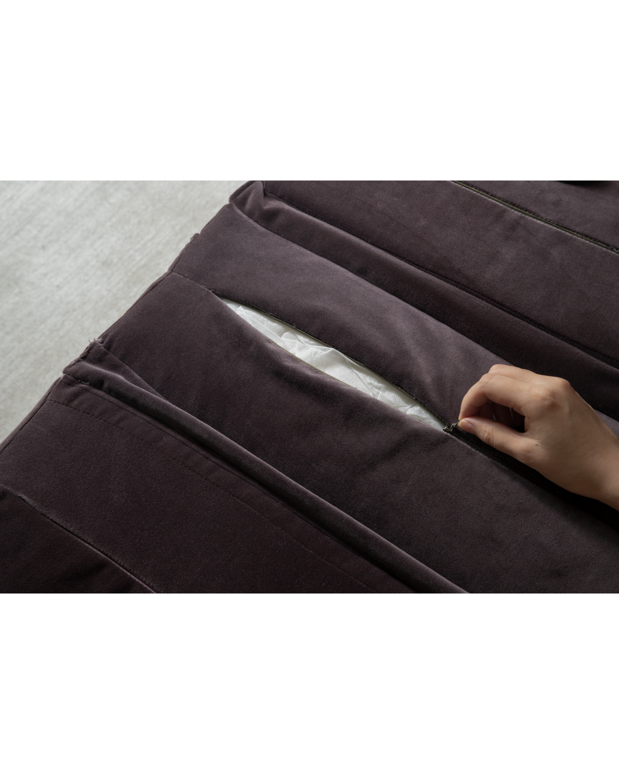 Hand unzipping plush velvet cushion cover on Bridget Bench