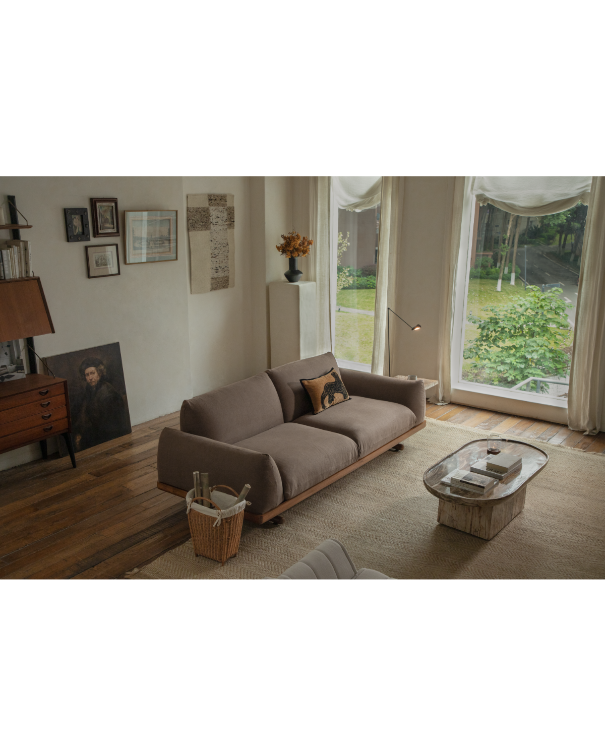 Adrian sofa with brown linen upholstery and teak wood base in a modern living room