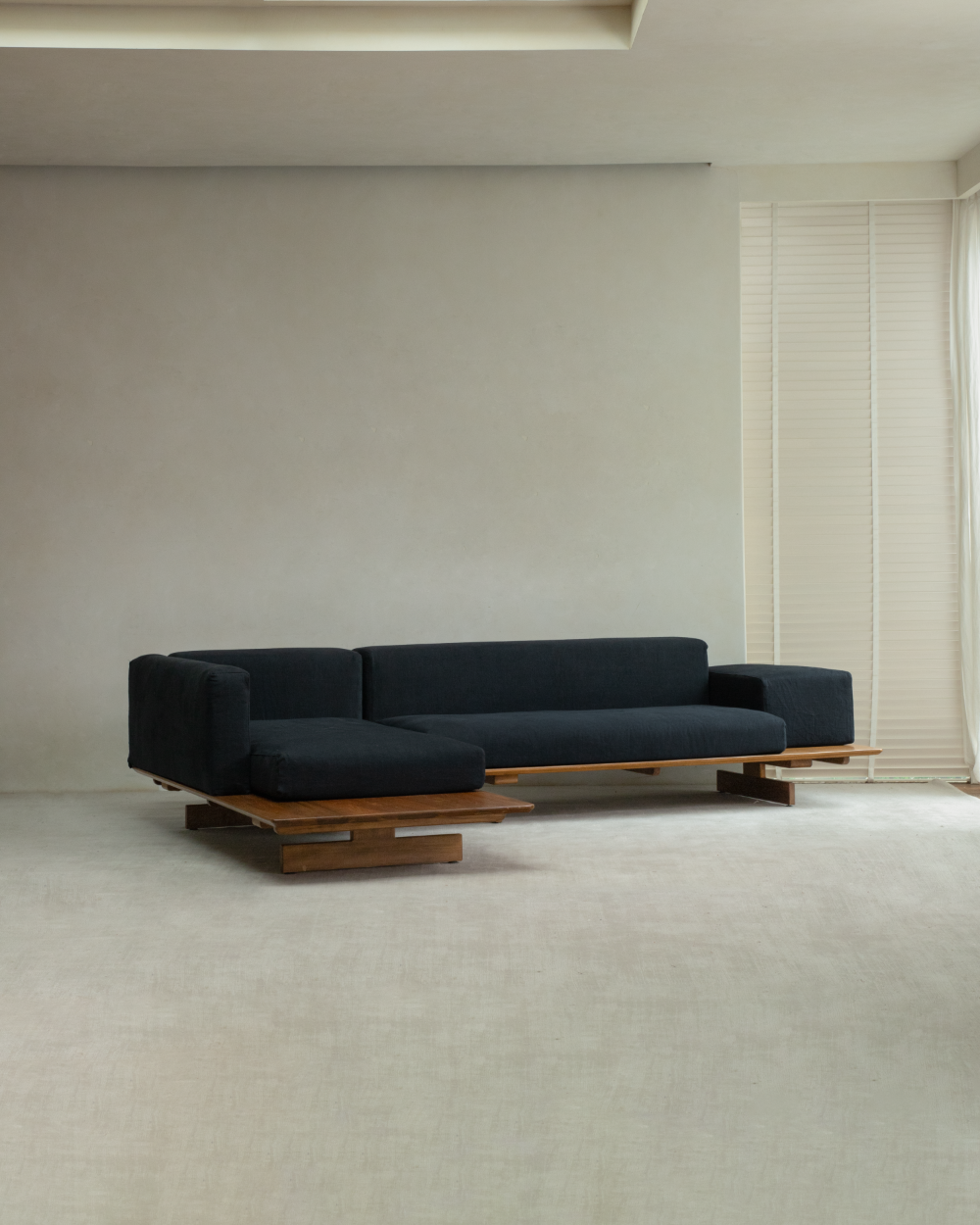 Black Tatami linen modular sofa with teak wood base, shown in L-shape configuration with chaise.