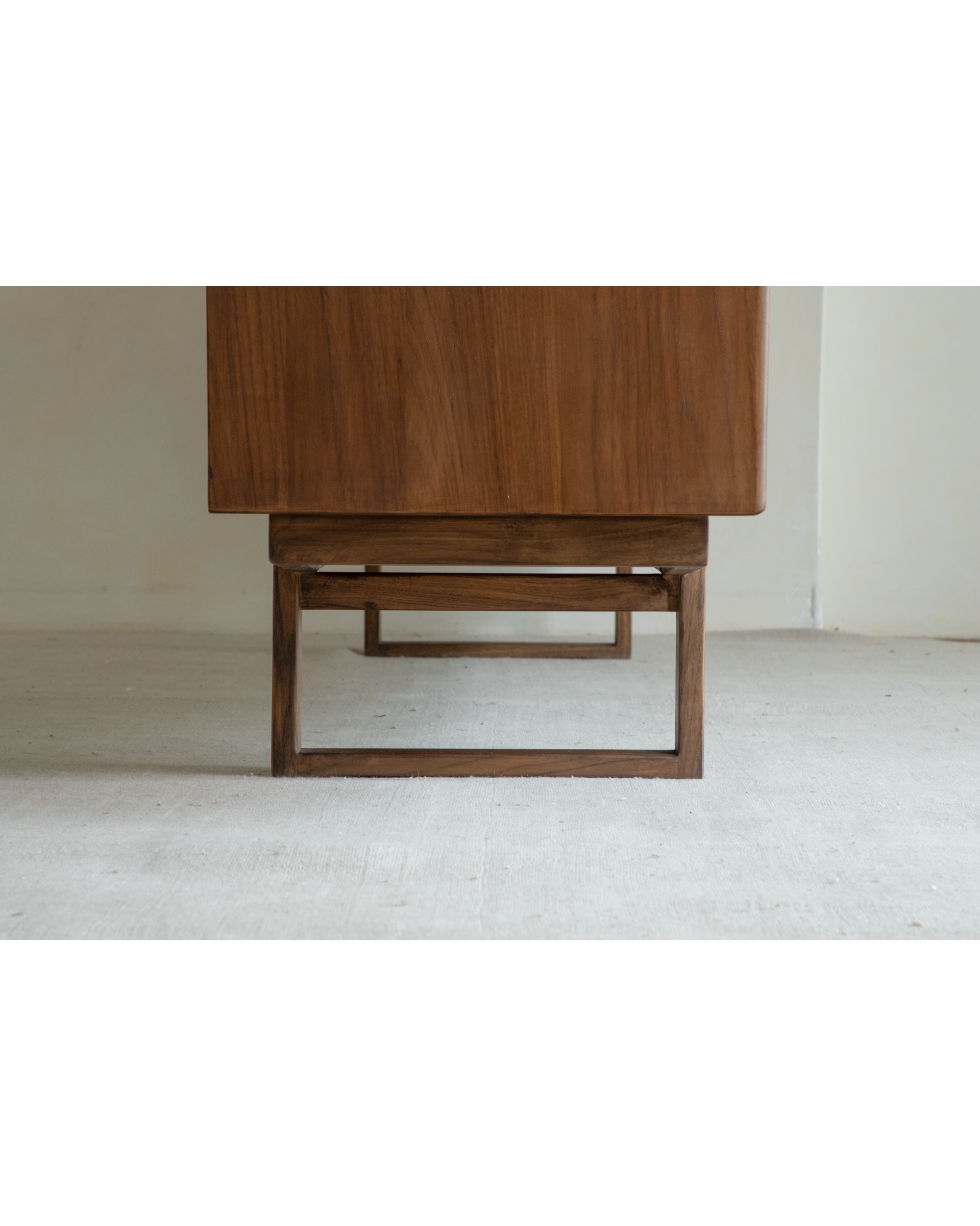 Mid-century teak veneer sideboard base with solid wood square legs.