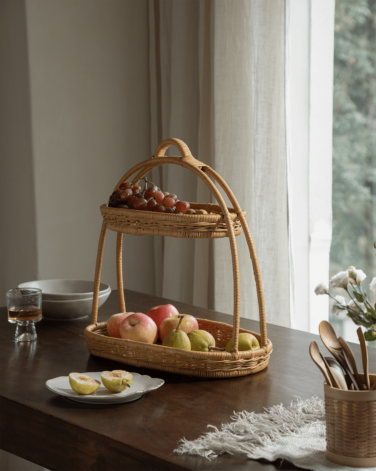Beatrice Stand: two-tier handwoven rattan serving tray with fruits.