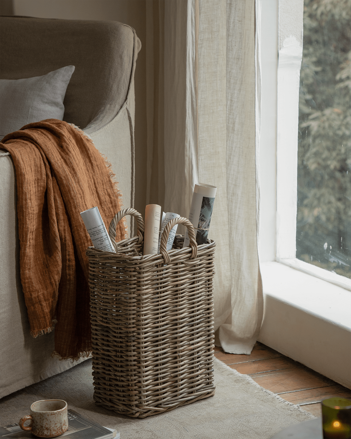 Handwoven natural rattan Oliver Basket with reinforced edges and rope handles, ideal for storage.