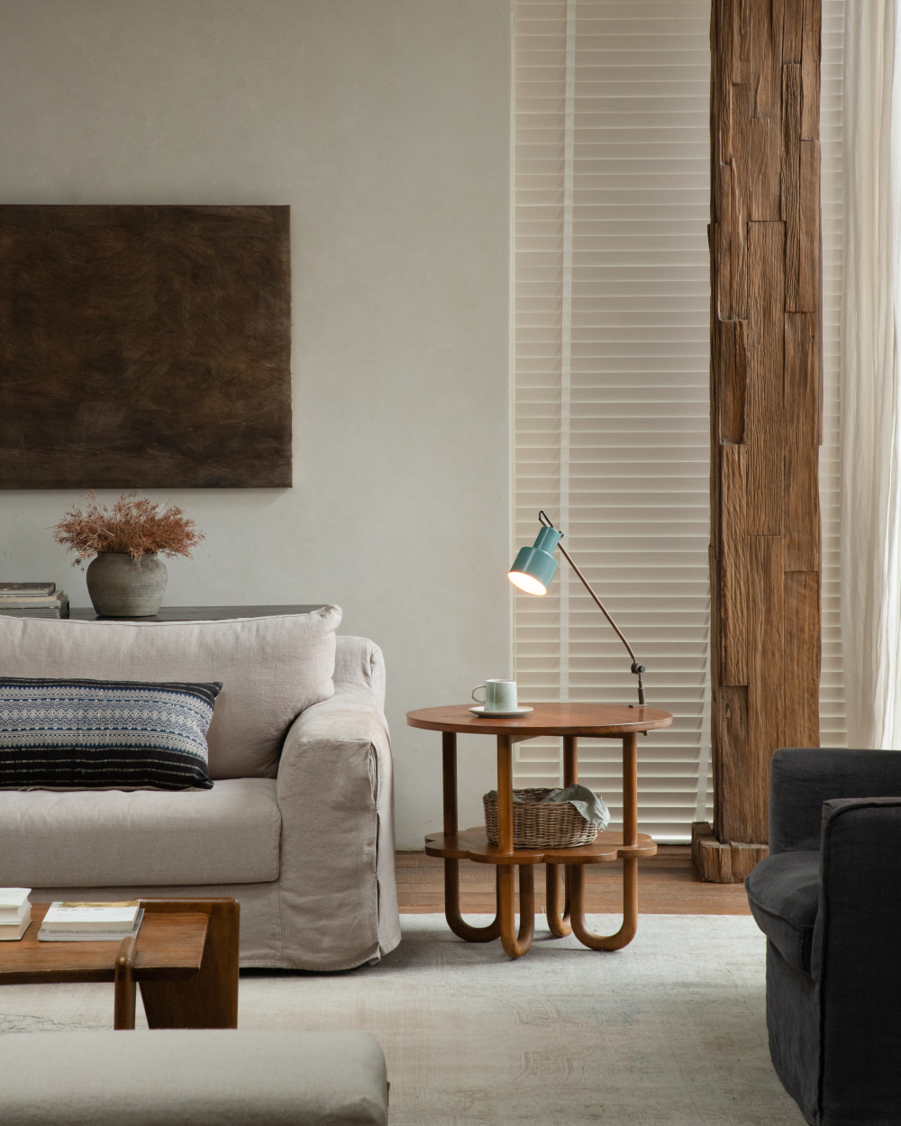 Daisy Side Table with curved wooden legs and a round top, featuring a teal lamp and a woven basket.