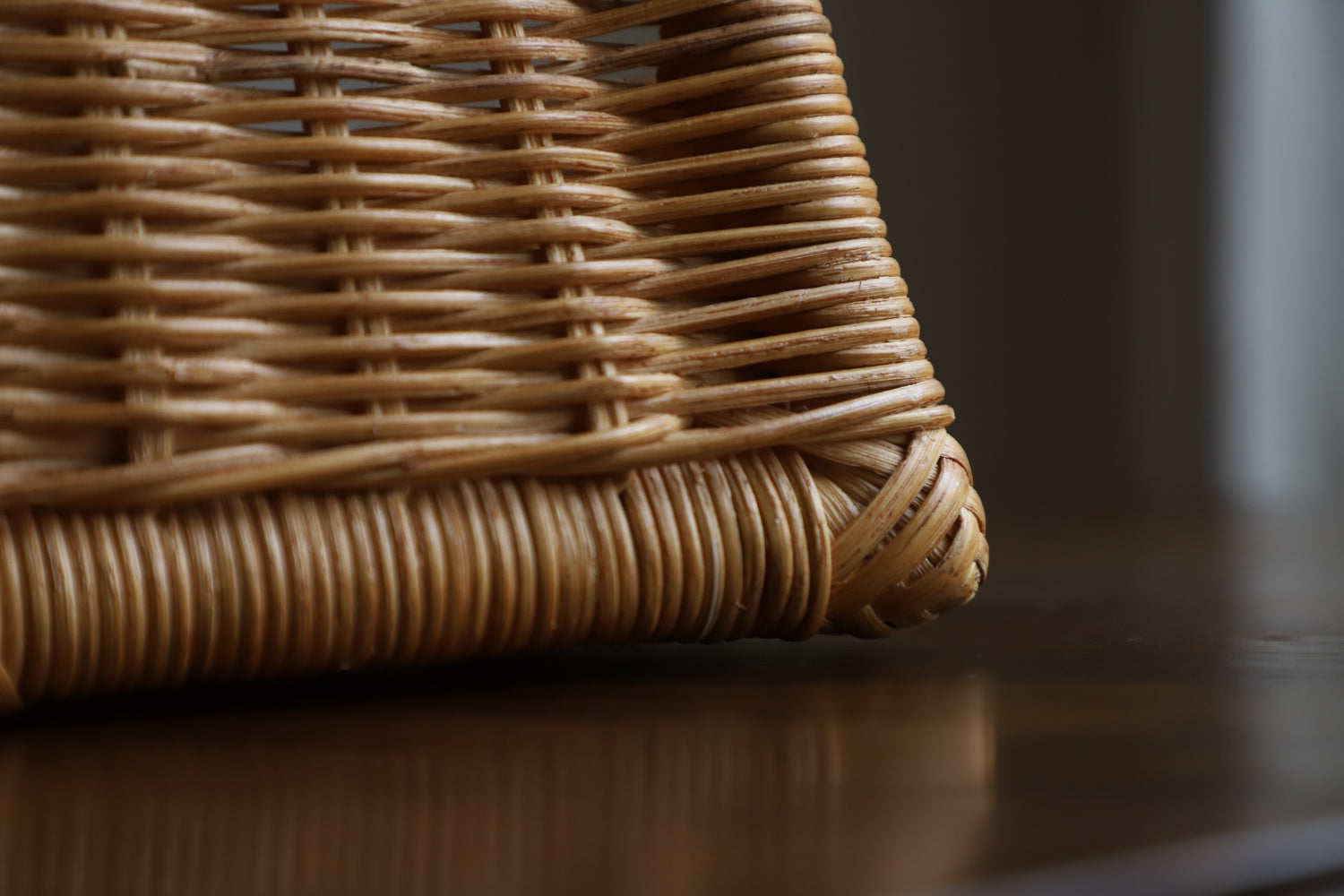 June Basket: Hand-woven natural rattan texture close-up.