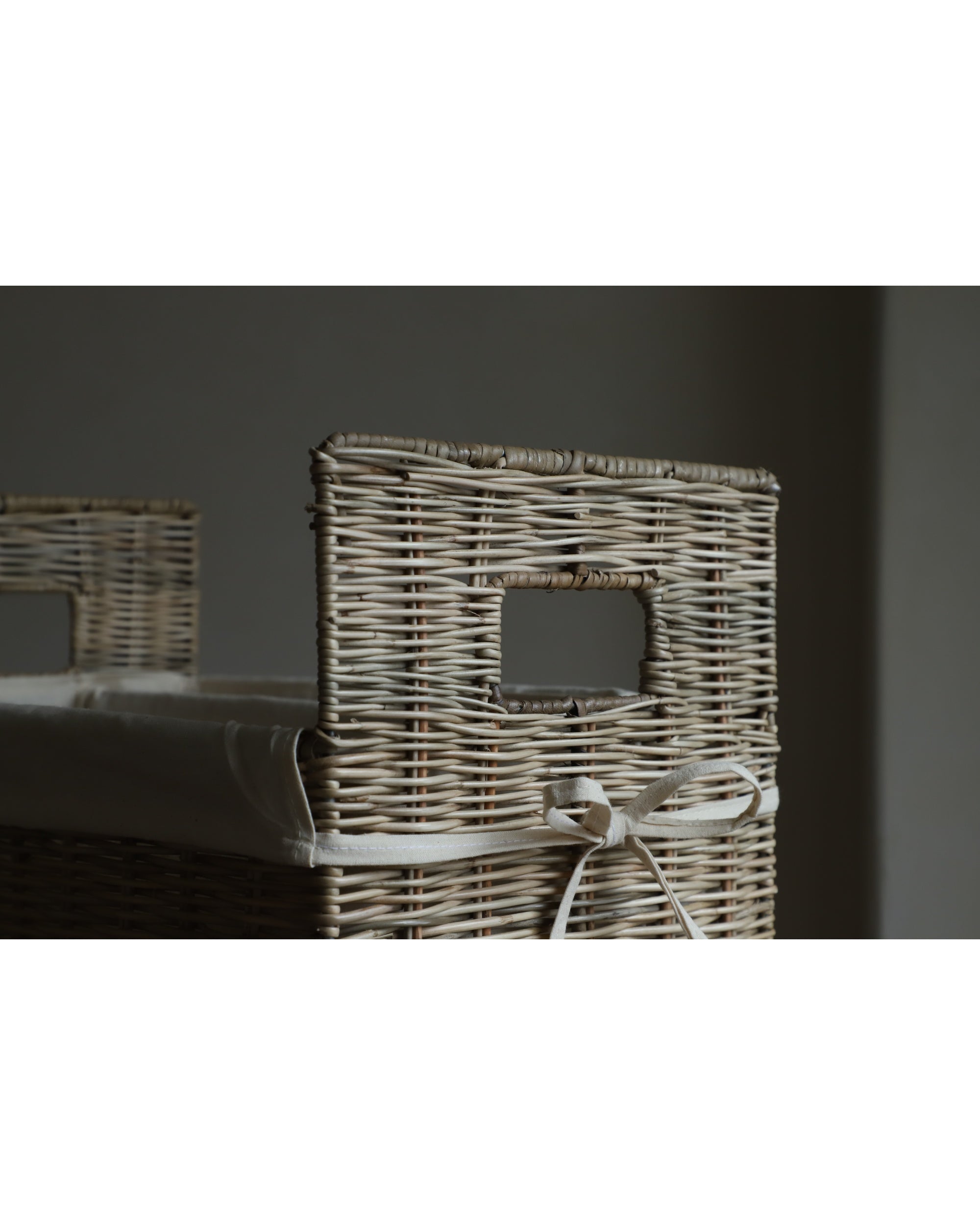 Natural rattan Elara storage basket with woven texture, integrated handles, and fabric lining.