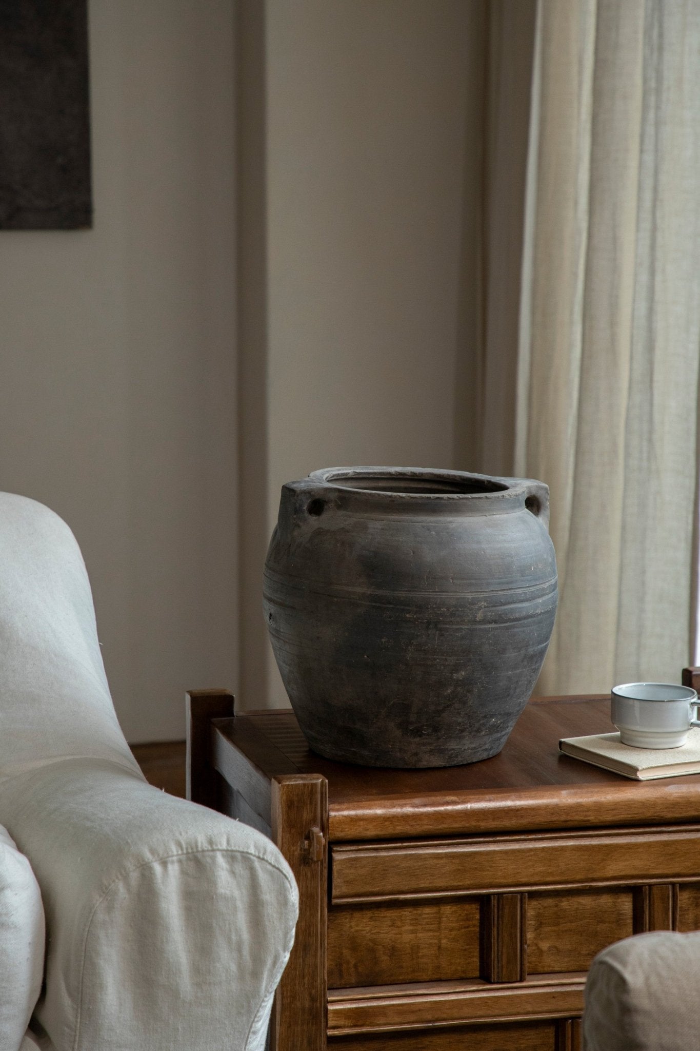 Vintage clay pot with handles, neutral home decor accent, on wooden table, clay material