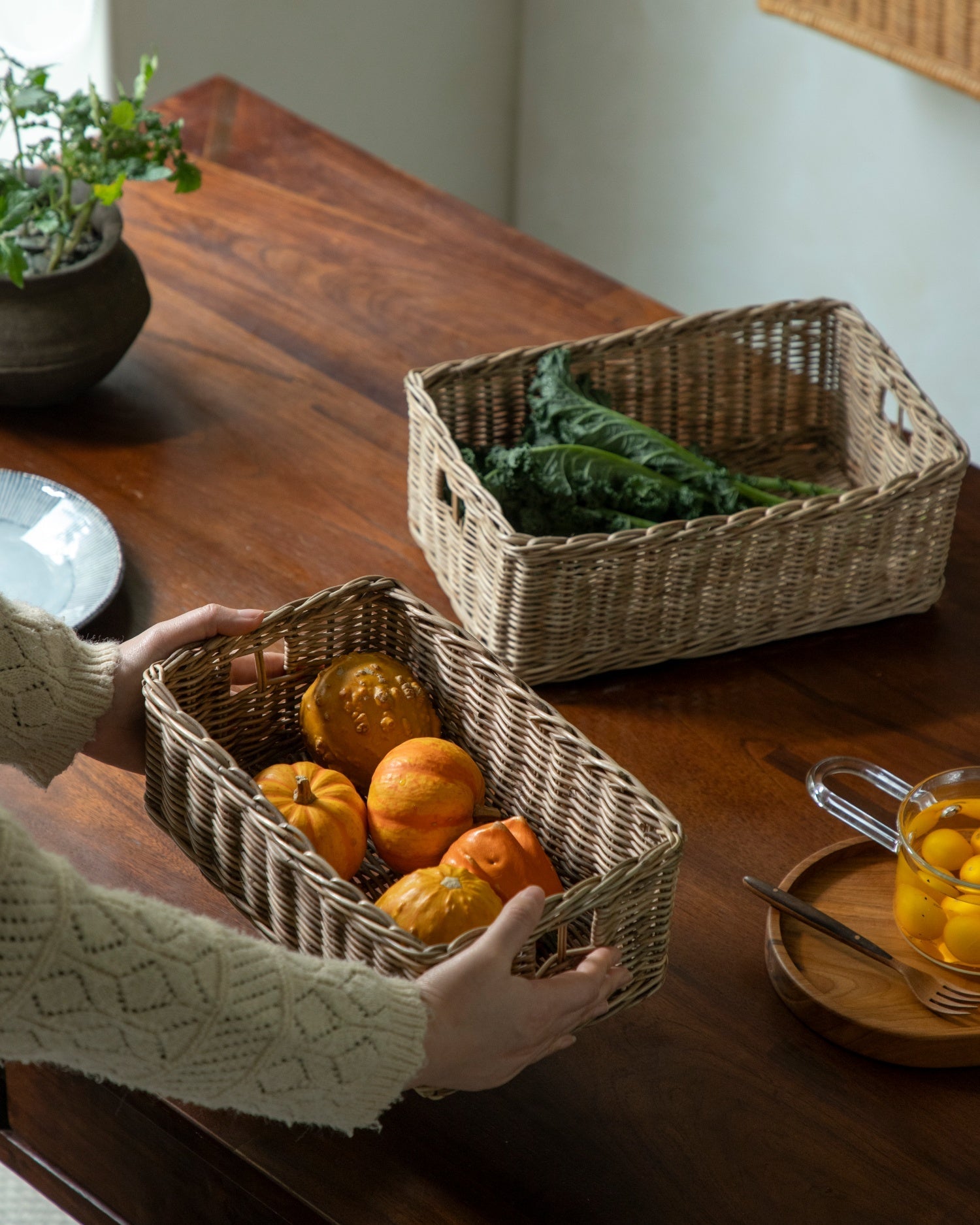 Etta hand-woven rattan storage basket with decorative pumpkins.