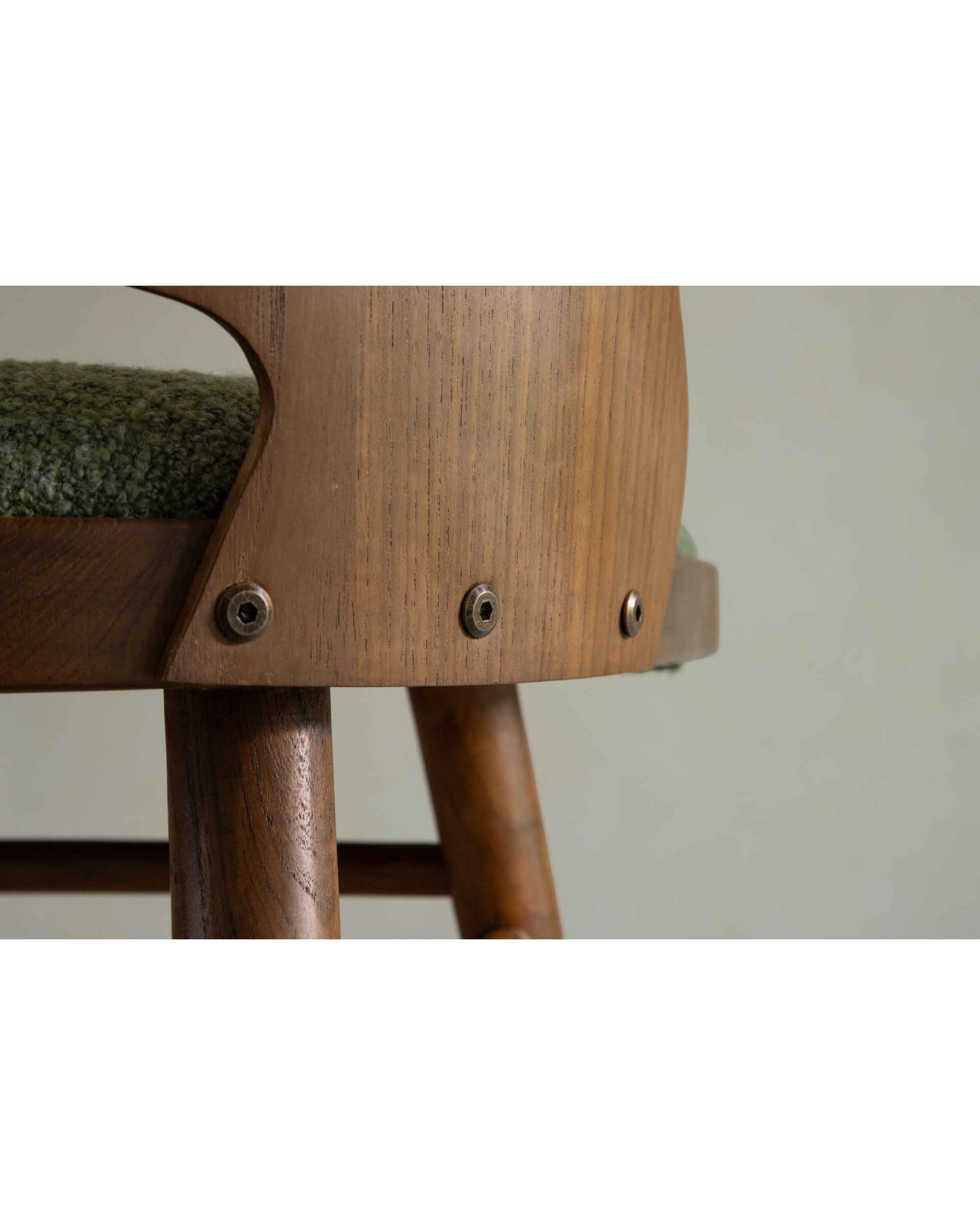 Shell Chair teak frame detail with curved backrest support and green upholstery.