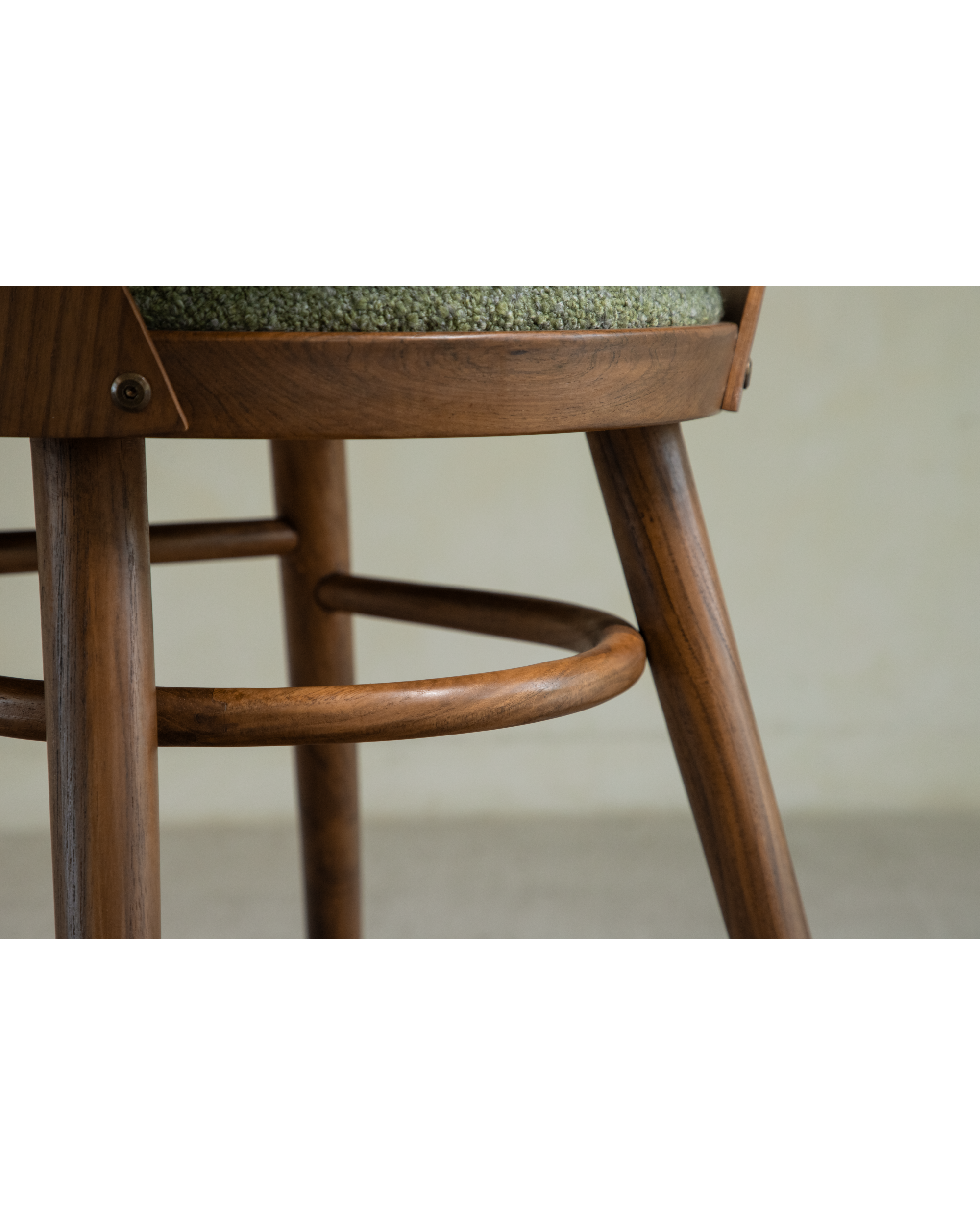 Shell Chair: Detailed view of solid wood frame, curved footrest, and green textured seat.