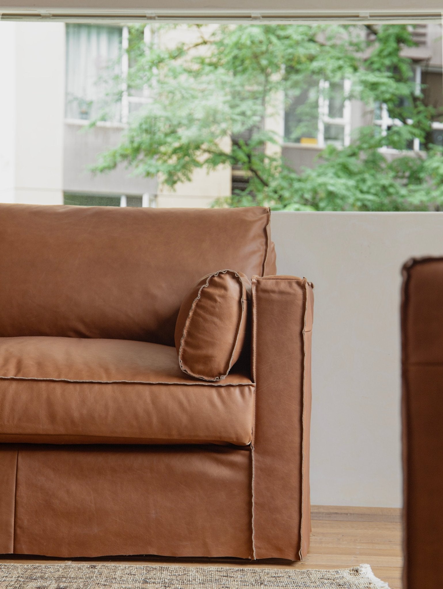 Brown top-grain leather skirt sofa detail, highlighting elegant design and exposed seams.