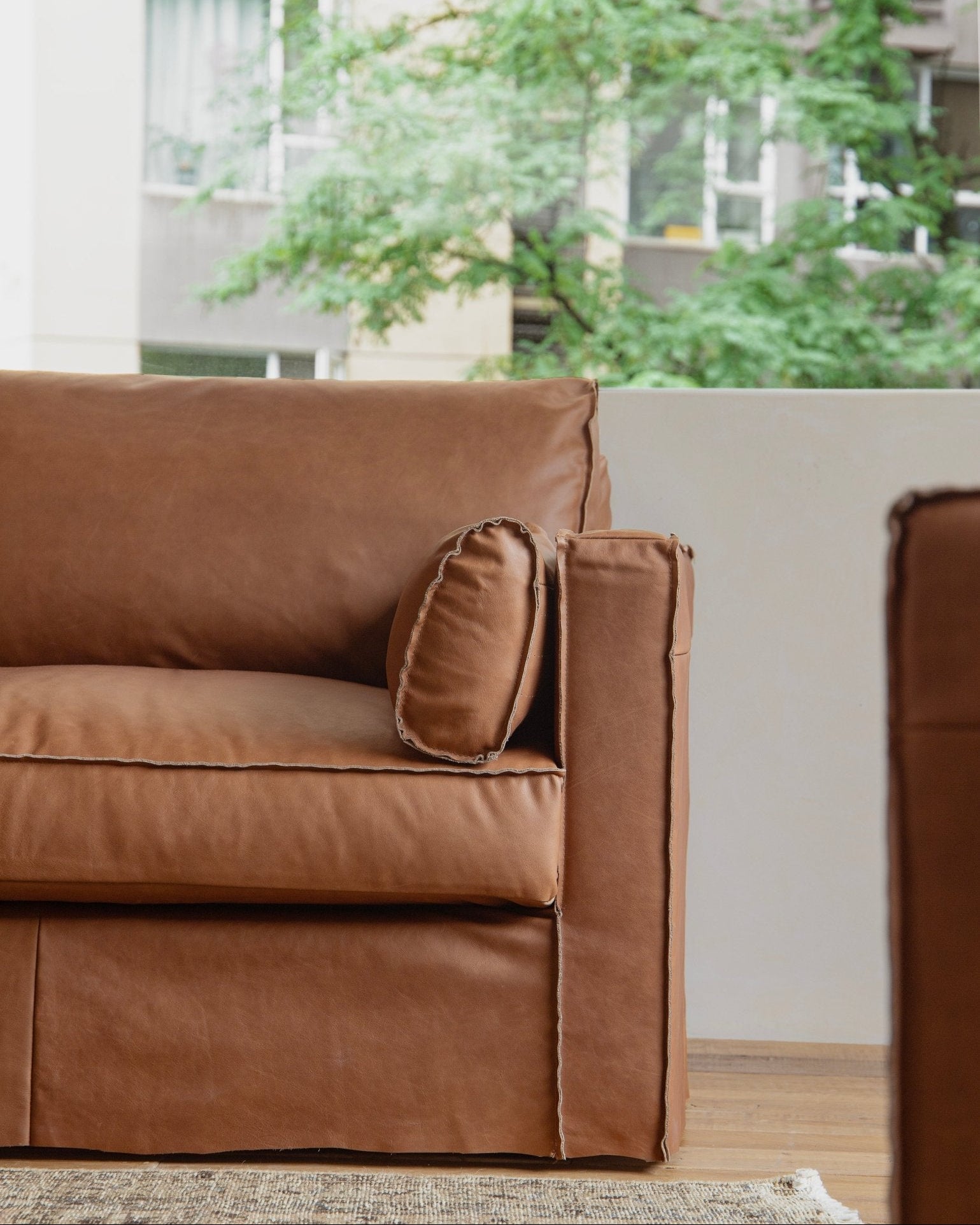 Brown top-grain leather skirt sofa detail, highlighting elegant design and exposed seams.