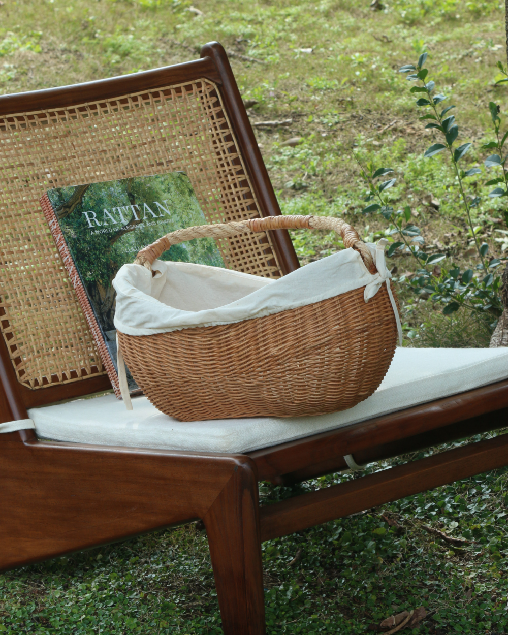 Handwoven Aurelia basket with white cotton lining and handle on wooden chair