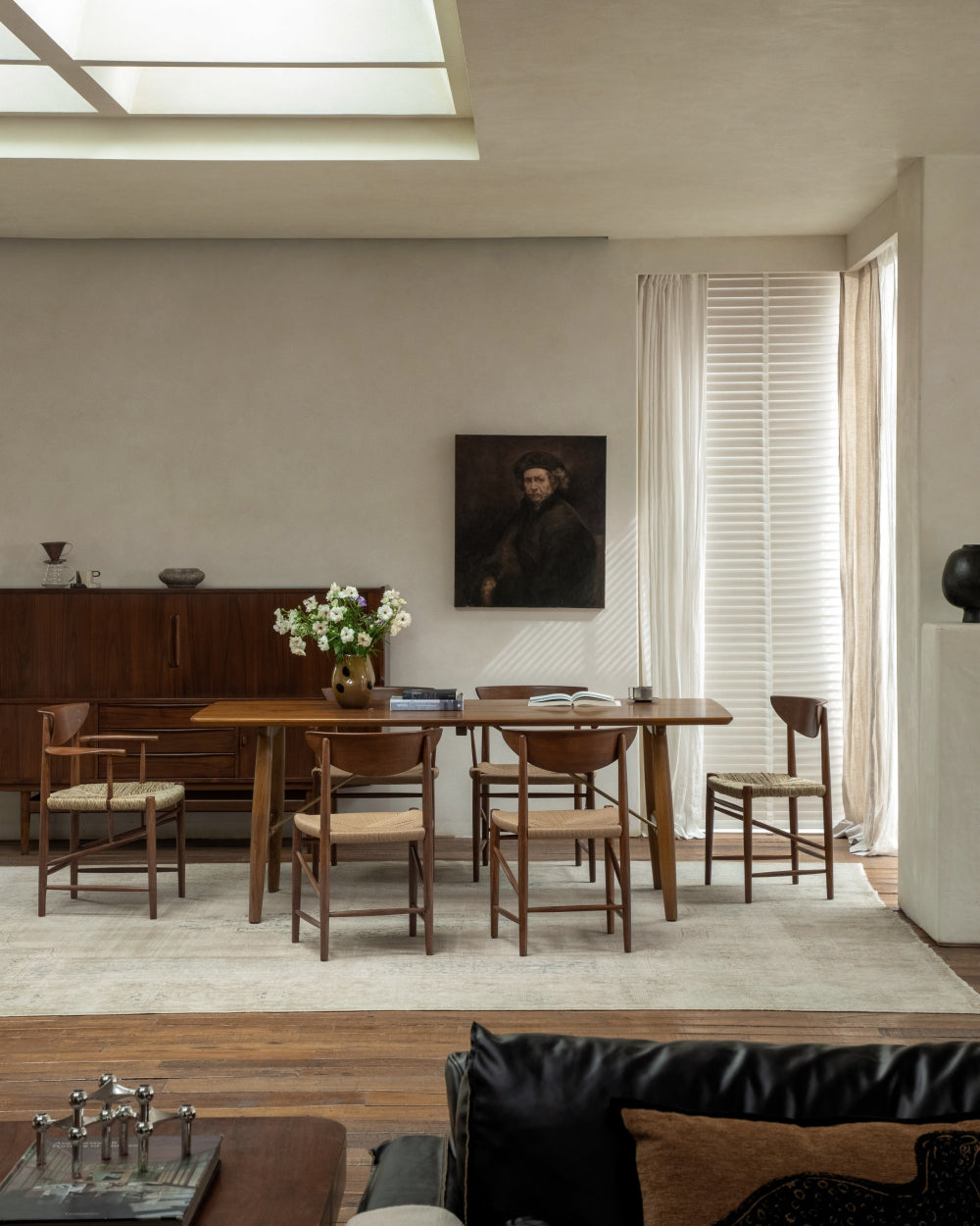 Henrik dining chairs featuring woven rush seats and teak wood frames.