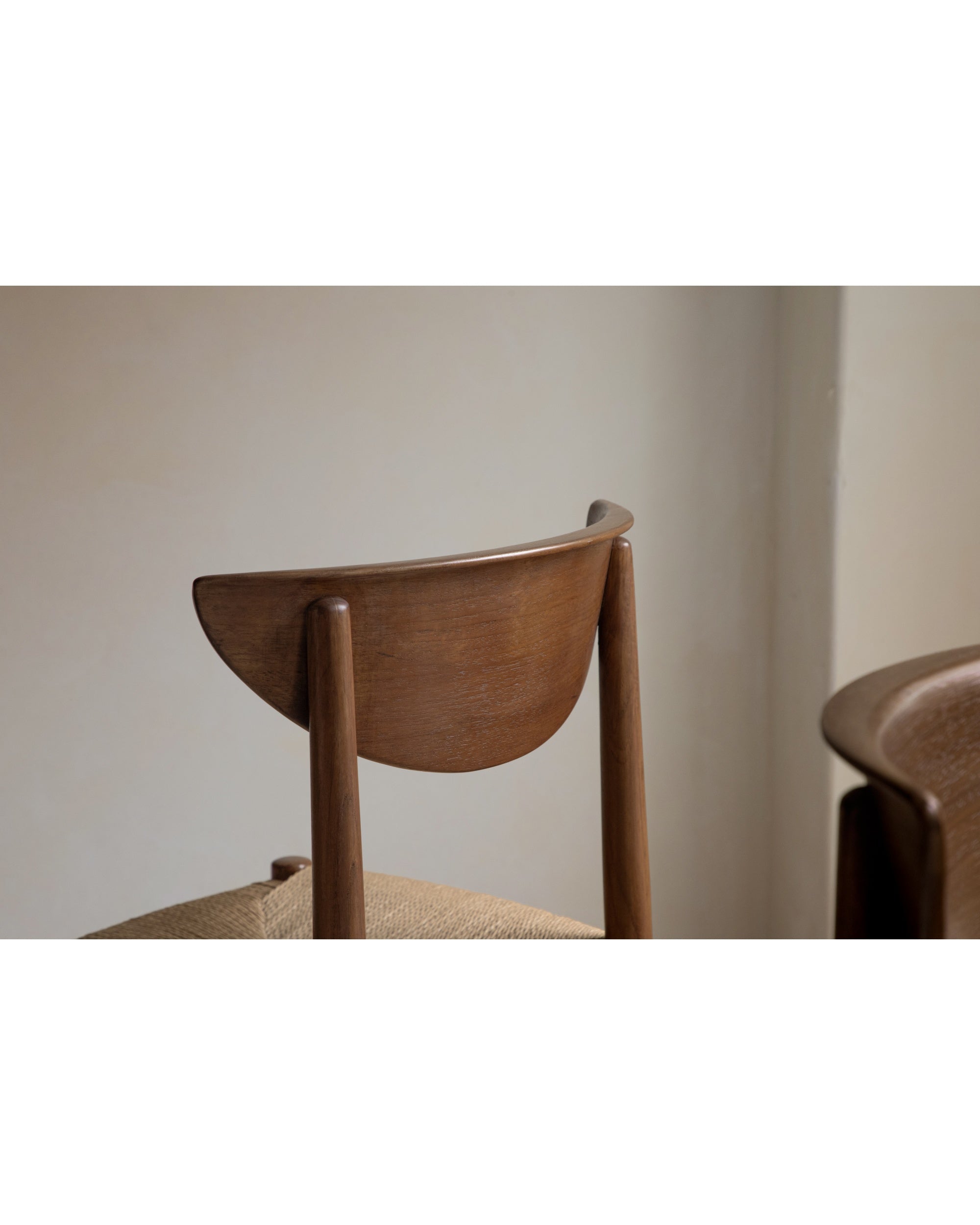 Margaret Dining Chair, featuring curved teak backrest and woven natural fiber seat.