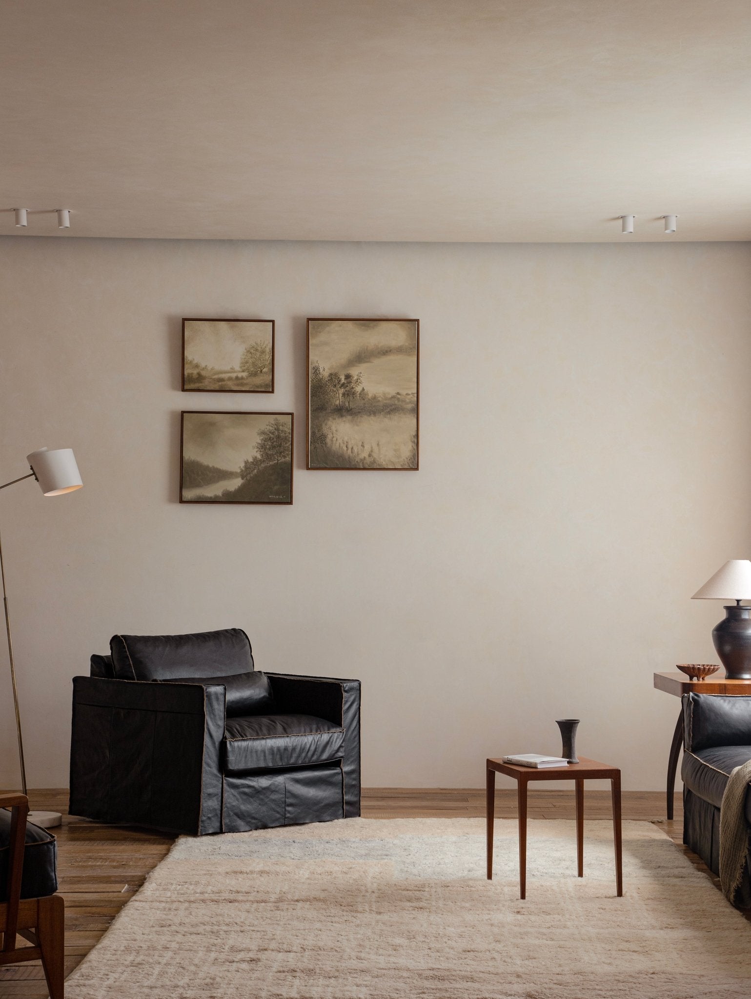 Black skirt leather armchair in a modern living room setting, emphasizing the elegant skirt design