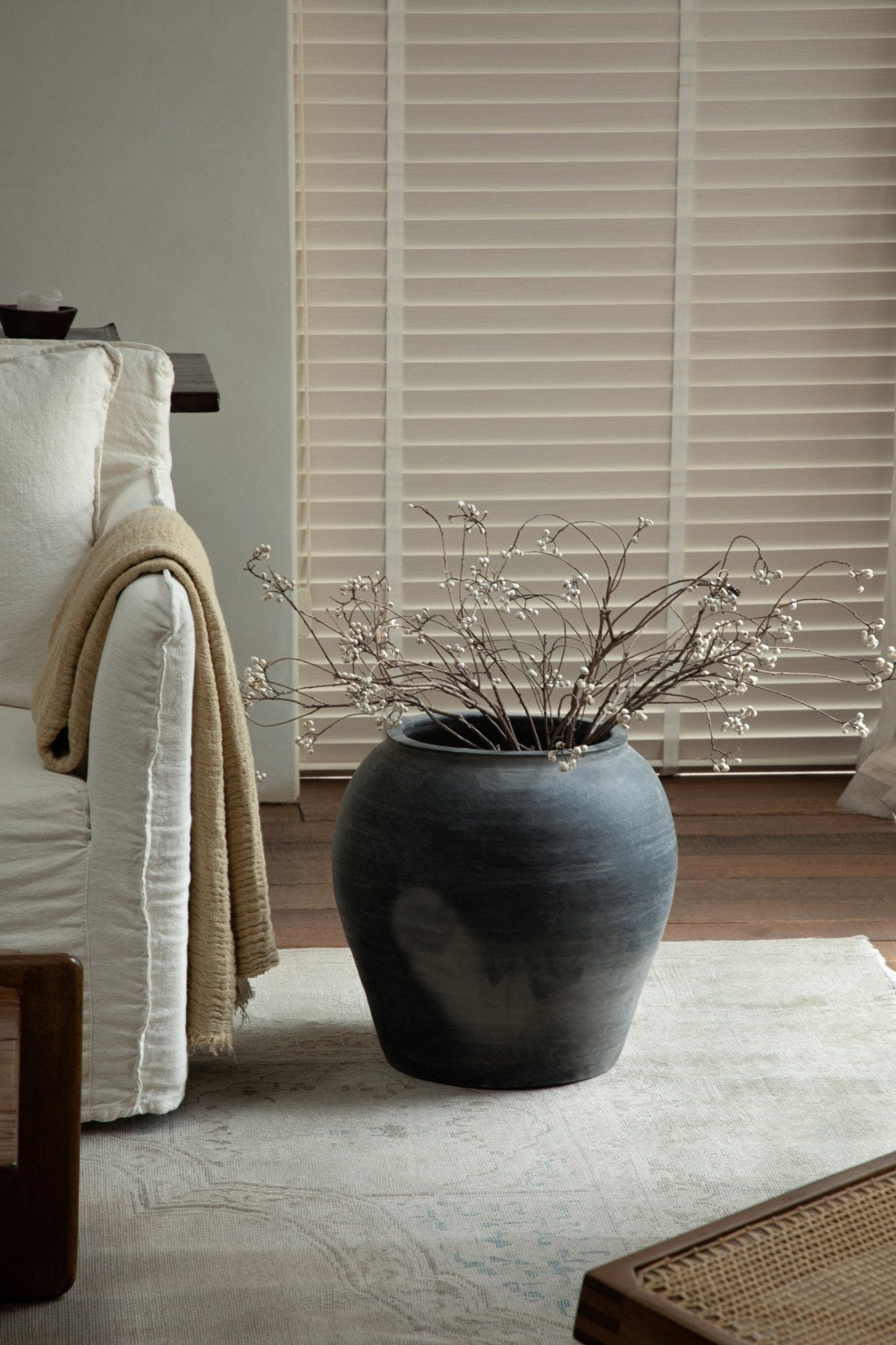 Large, dark gray vintage clay pot with dried branches, neutral home decor accent. Clay material.