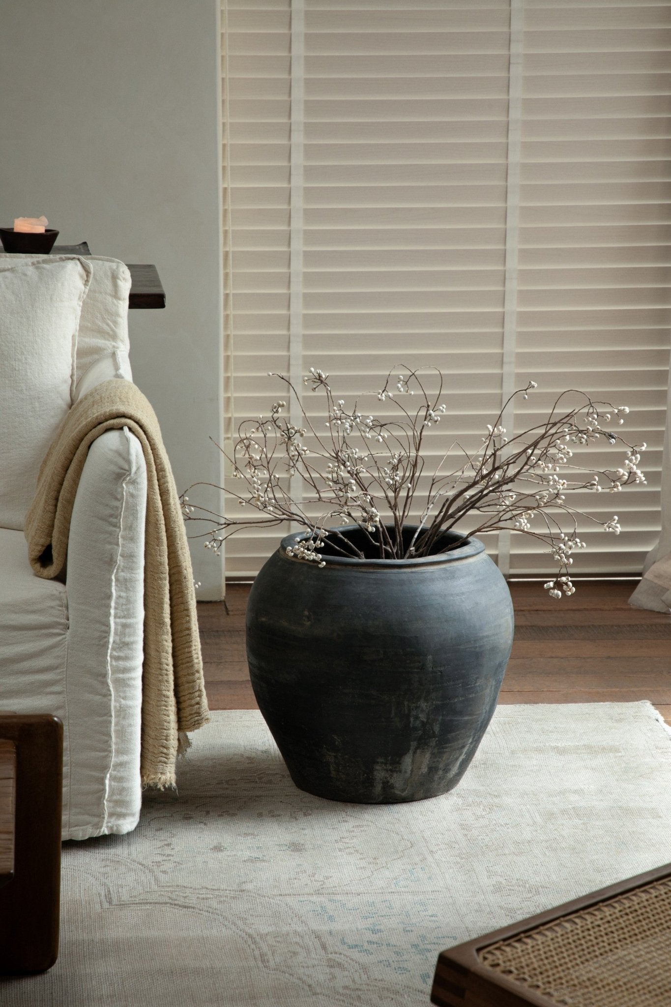 Large vintage clay pot, filled with branches. Neutral home decor accent, clay material.