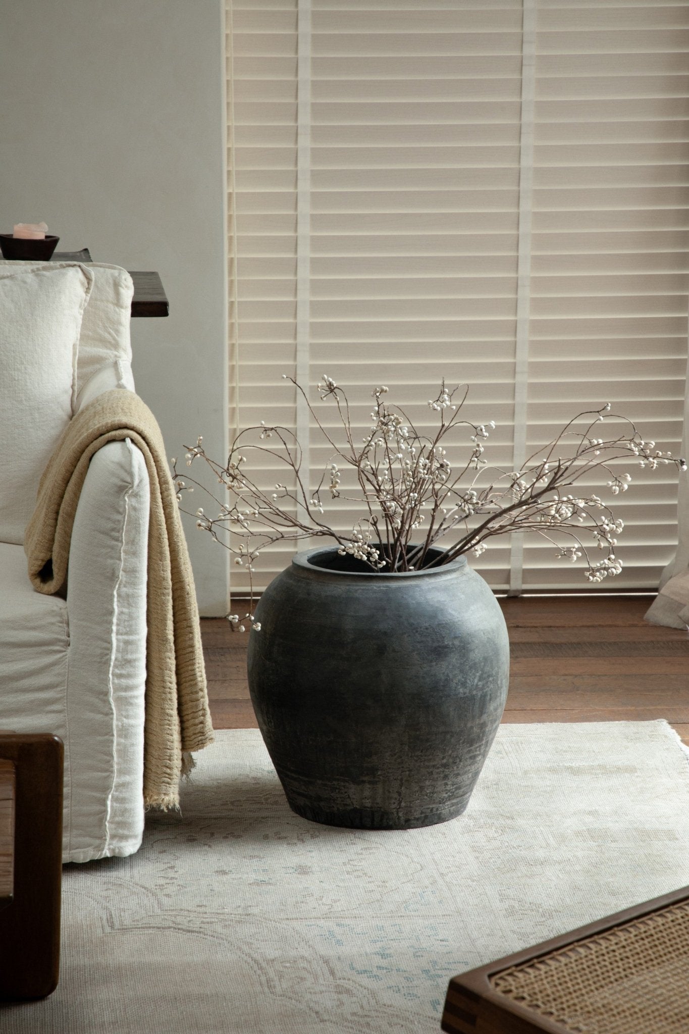 Large clay pot with branches, neutral color home decor accent, clay material.