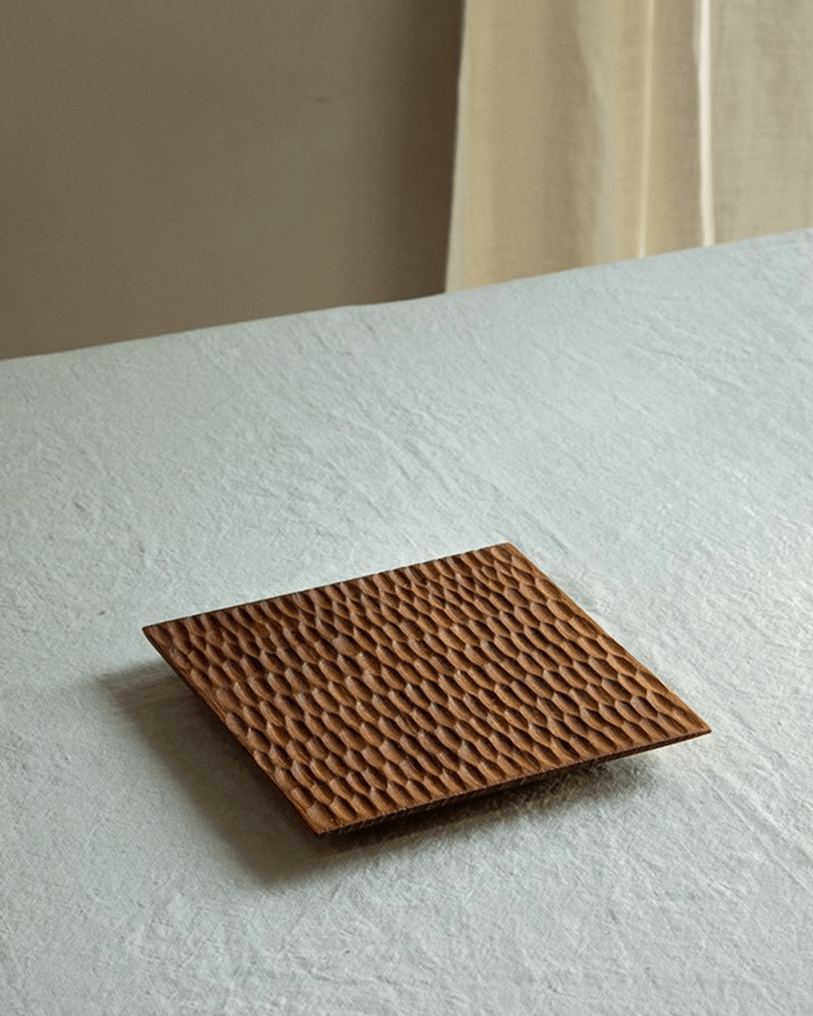 Handcrafted teak wood serving tray with textured artisan design, perfect for food display