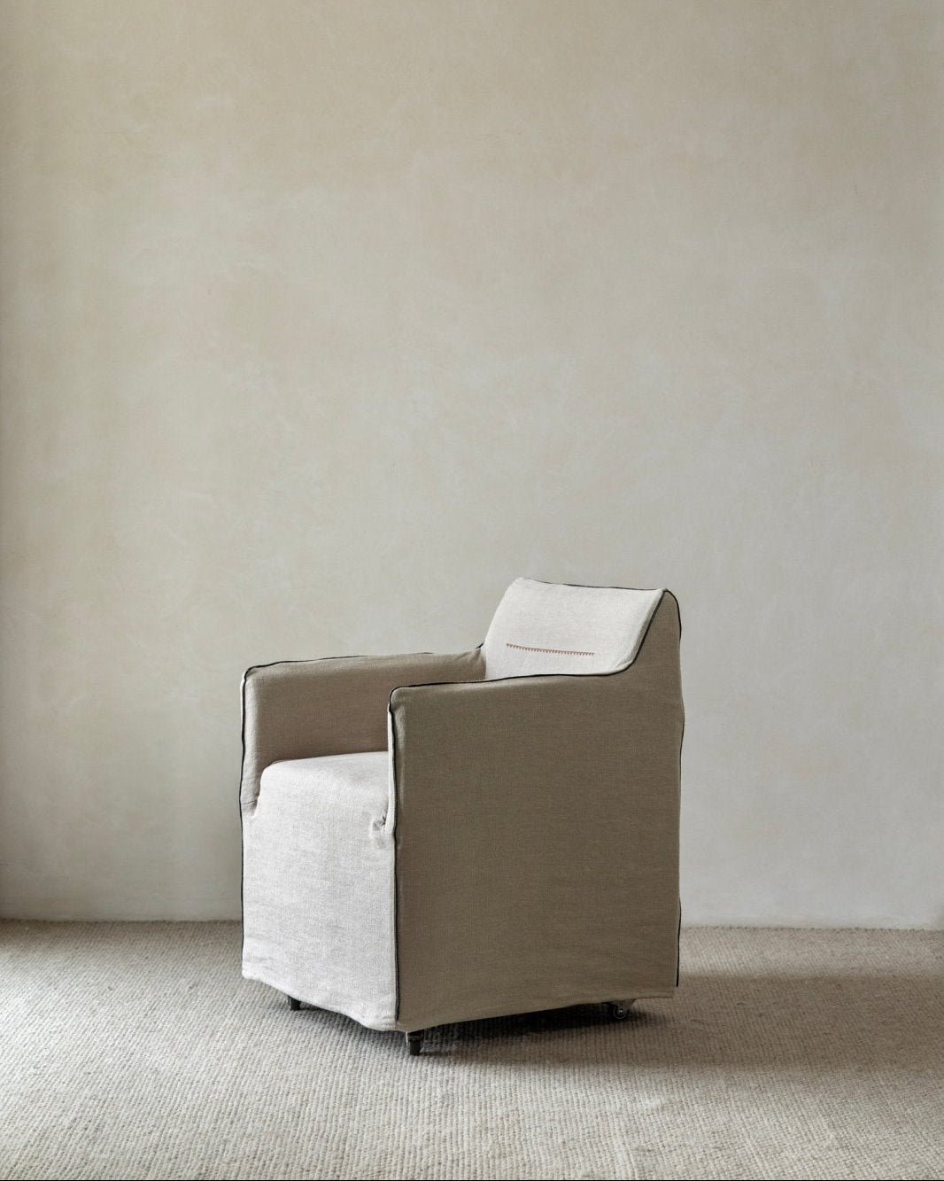 Ducy Linen Slipcover Chair in white with dark piping and linen fabric.