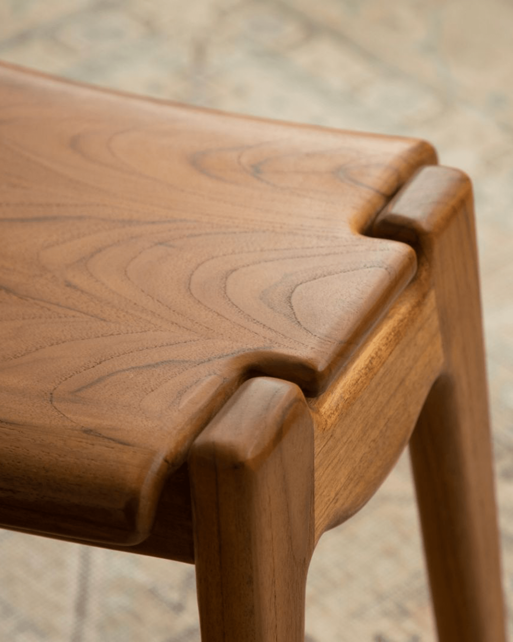 Zen Armchair detail, light brown wood with ergonomic design, focus on joinery and wood grain, promoting relaxation