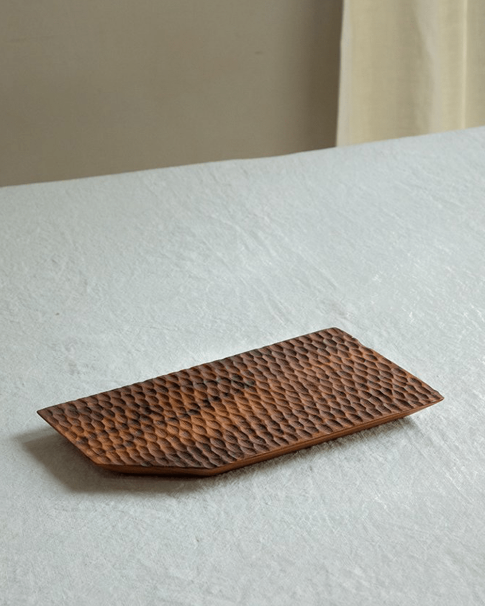 Handcrafted teak wood serving tray with textured surface, perfect for food display.