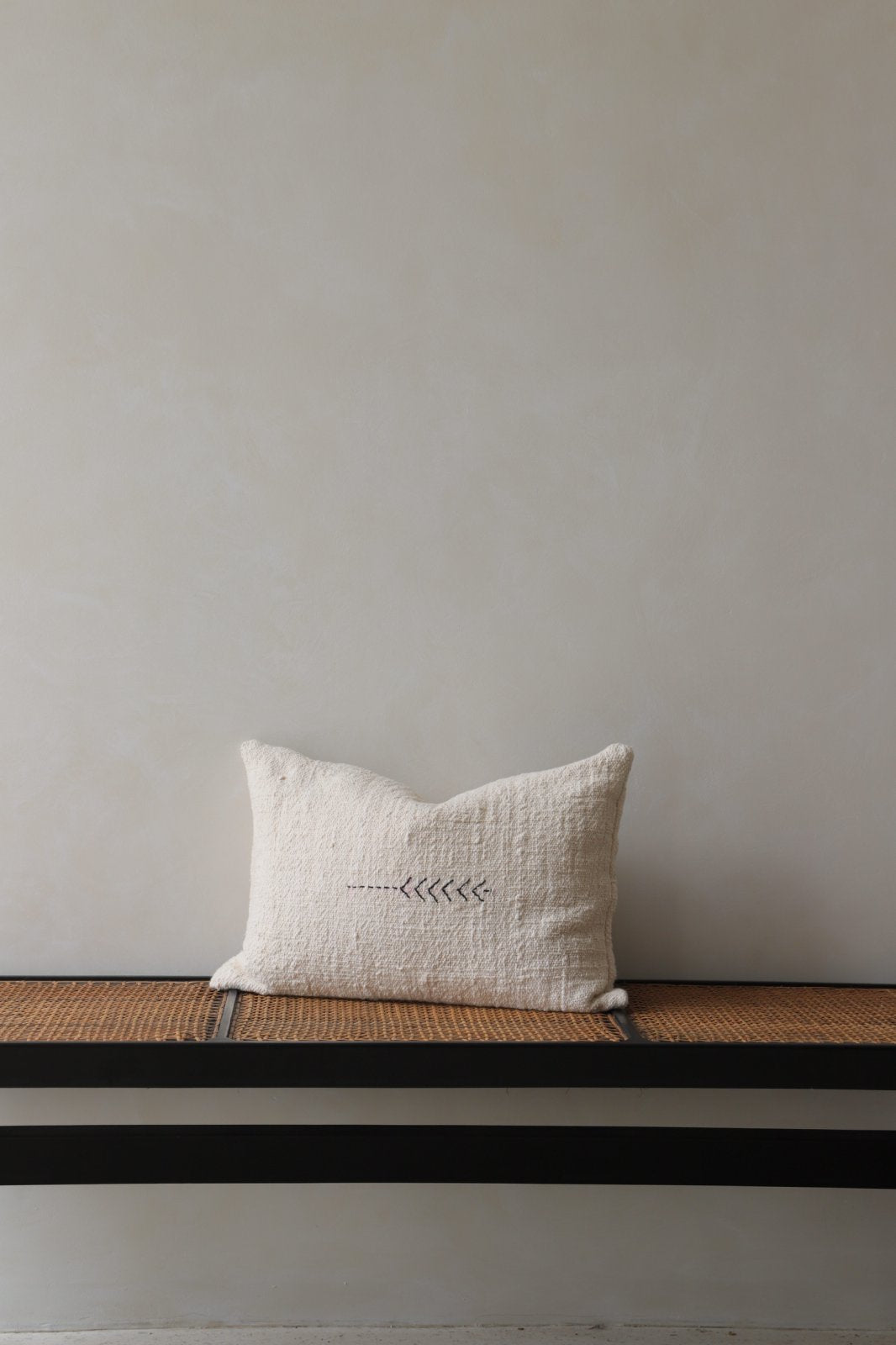 Cotton pillow with stitched design, neutral color, on a bench, part of a modern home decor