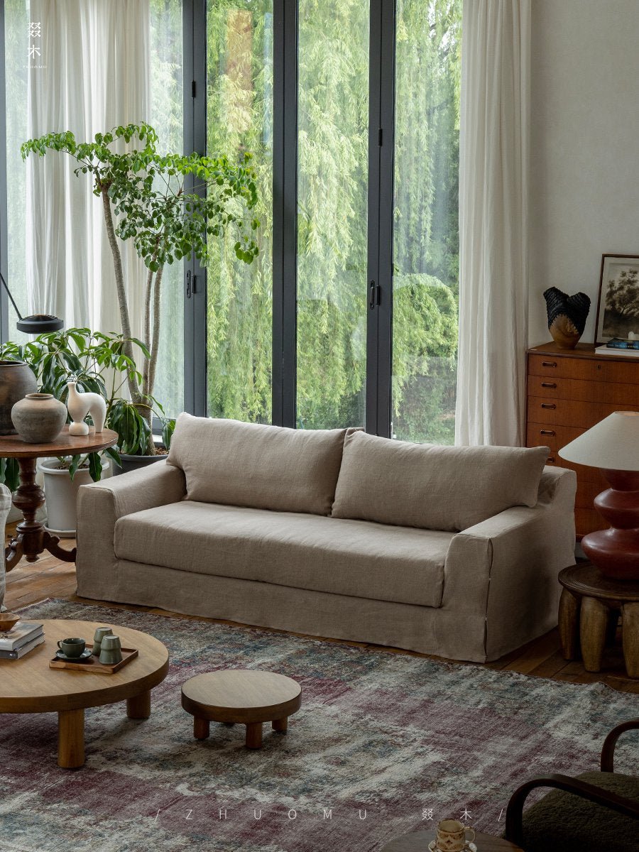 Beige Guni Linen Sofa in a cozy living room setting. Linen fabric sofa with wooden furniture and natural textures.