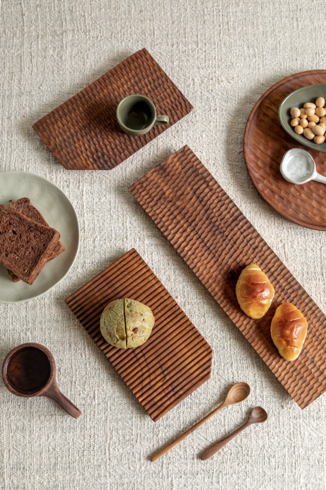 Assortment of food on handcrafted teak wood serving trays, ideal for serving and display, Artisan design.