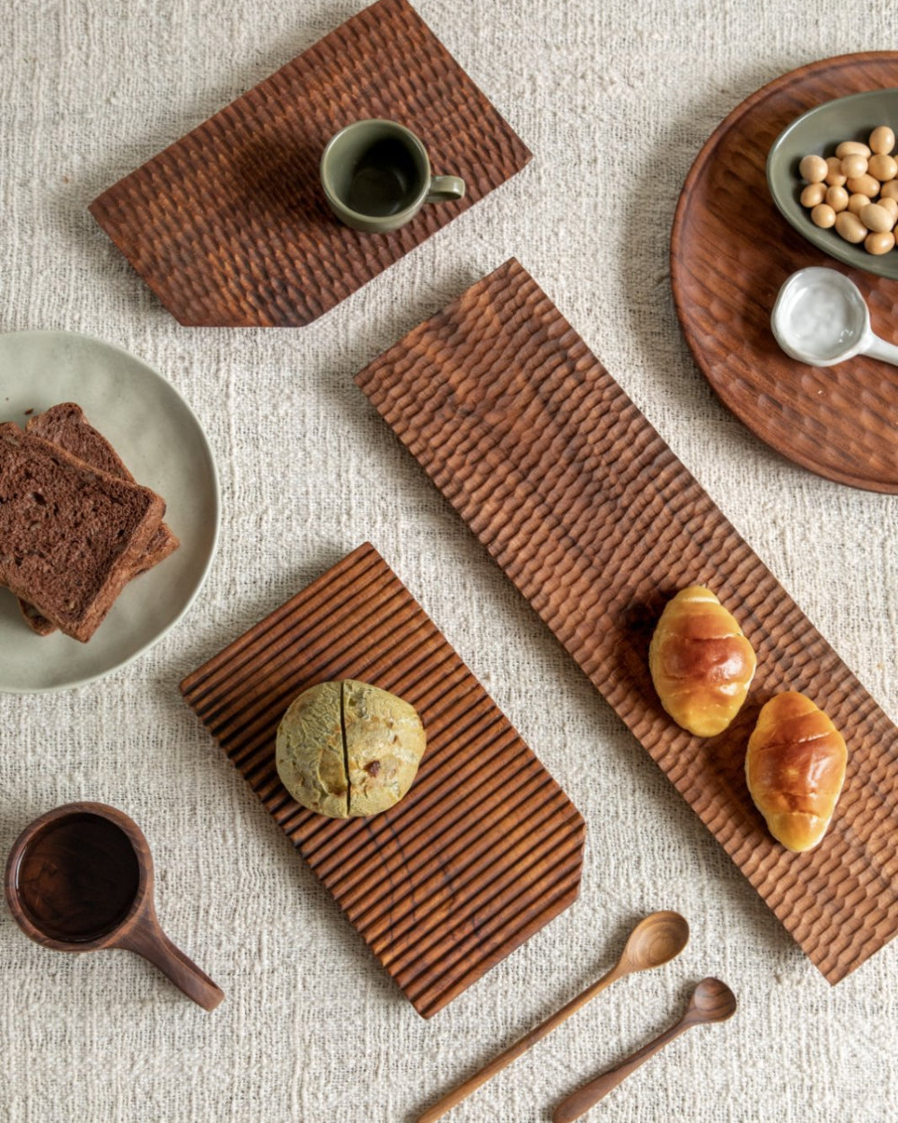 Assortment of food on handcrafted teak wood serving trays, ideal for serving and display, Artisan design.