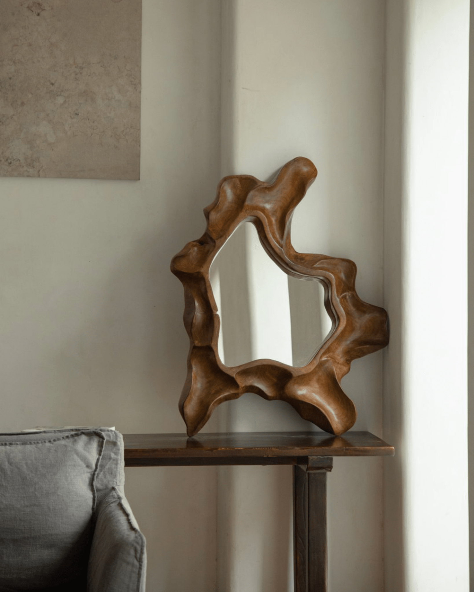 Organic Wood Arbor Mirror displayed on dark wood table, modern wall decor.