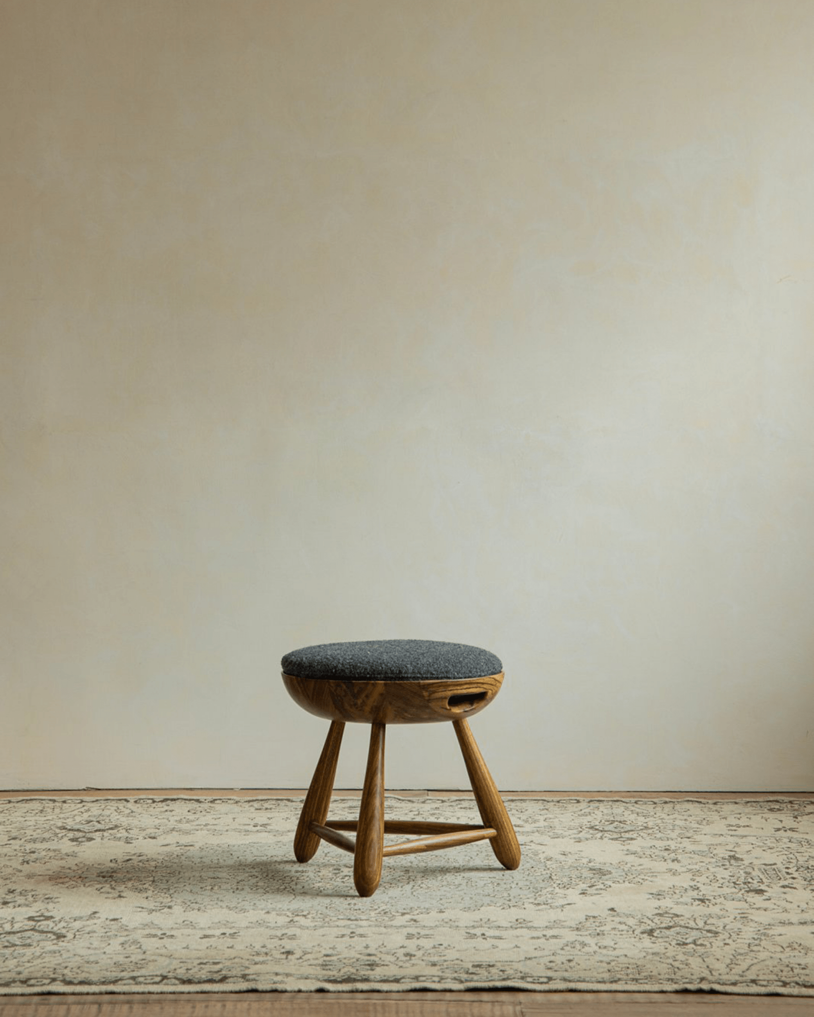 Zebrawood Mocho Stool with gray cushioned seat and tripod legs. Modern organic design.