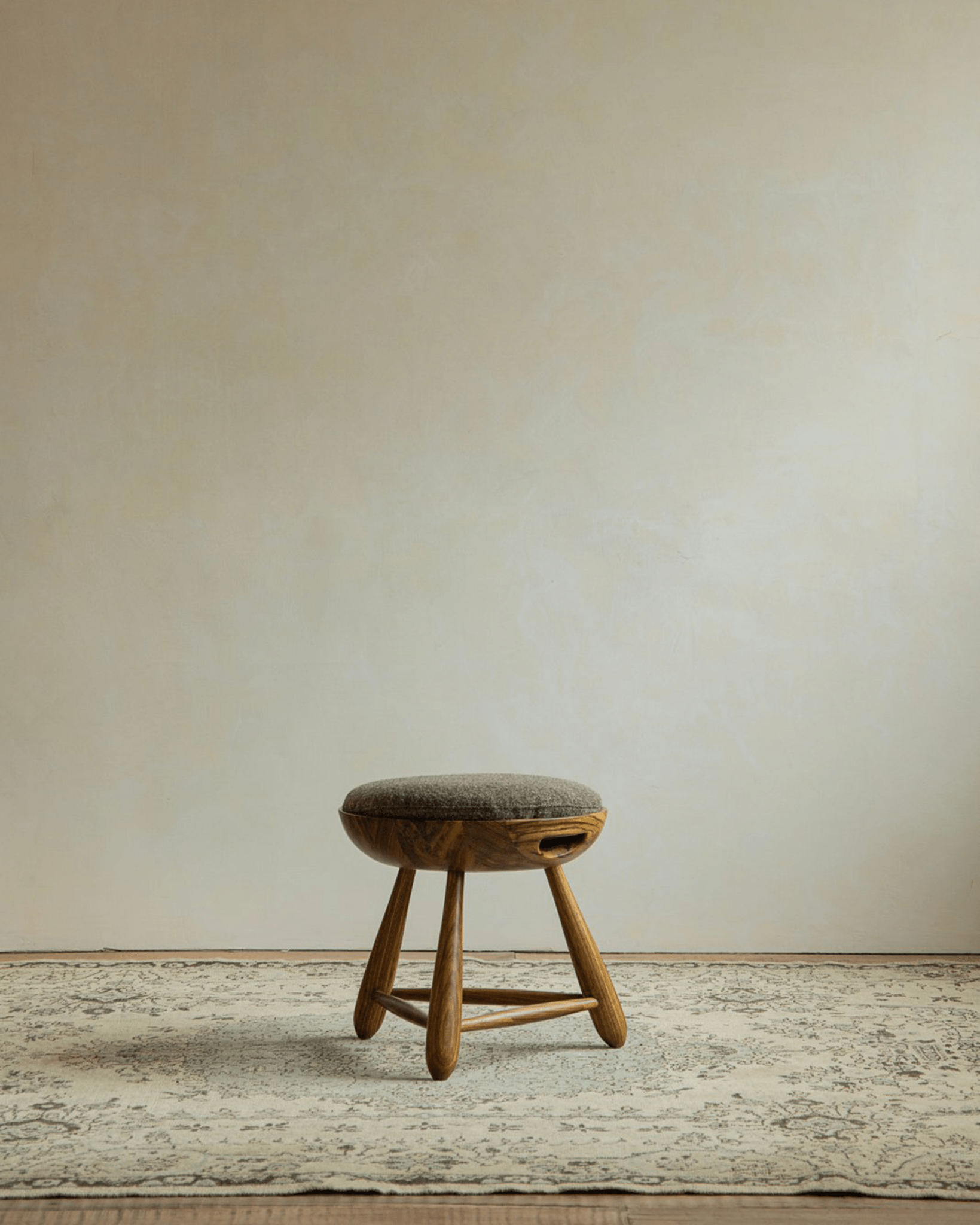 Zebrawood Mocho stool with gray upholstered seat and organic design. Modern stool for modern living spaces.