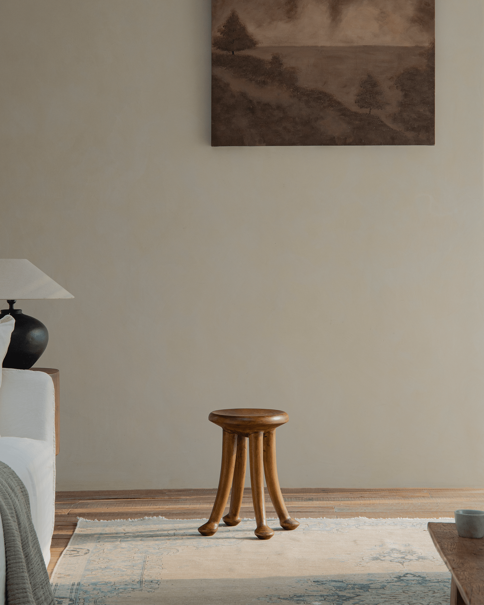 Sploot Stool in a modern interior, crafted from Samanea saman wood, natural color, three-legged design