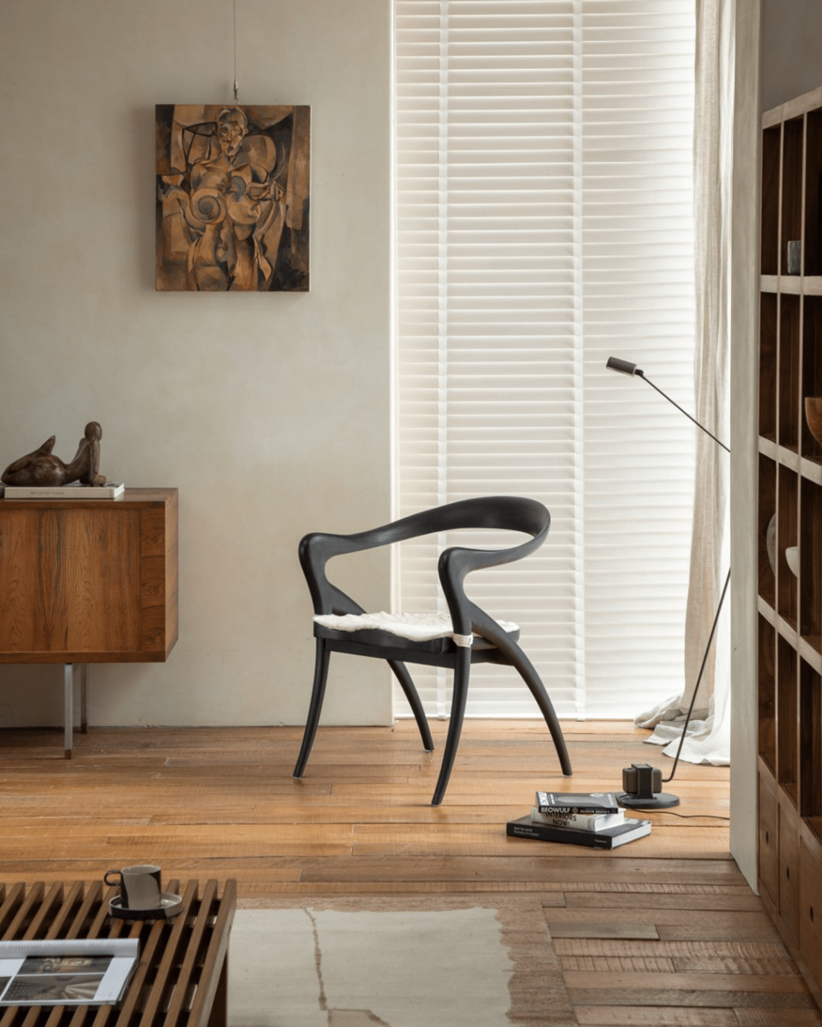 Black Olivia Chair in modern interior. Curved back, contoured seat, solid teak wood.
